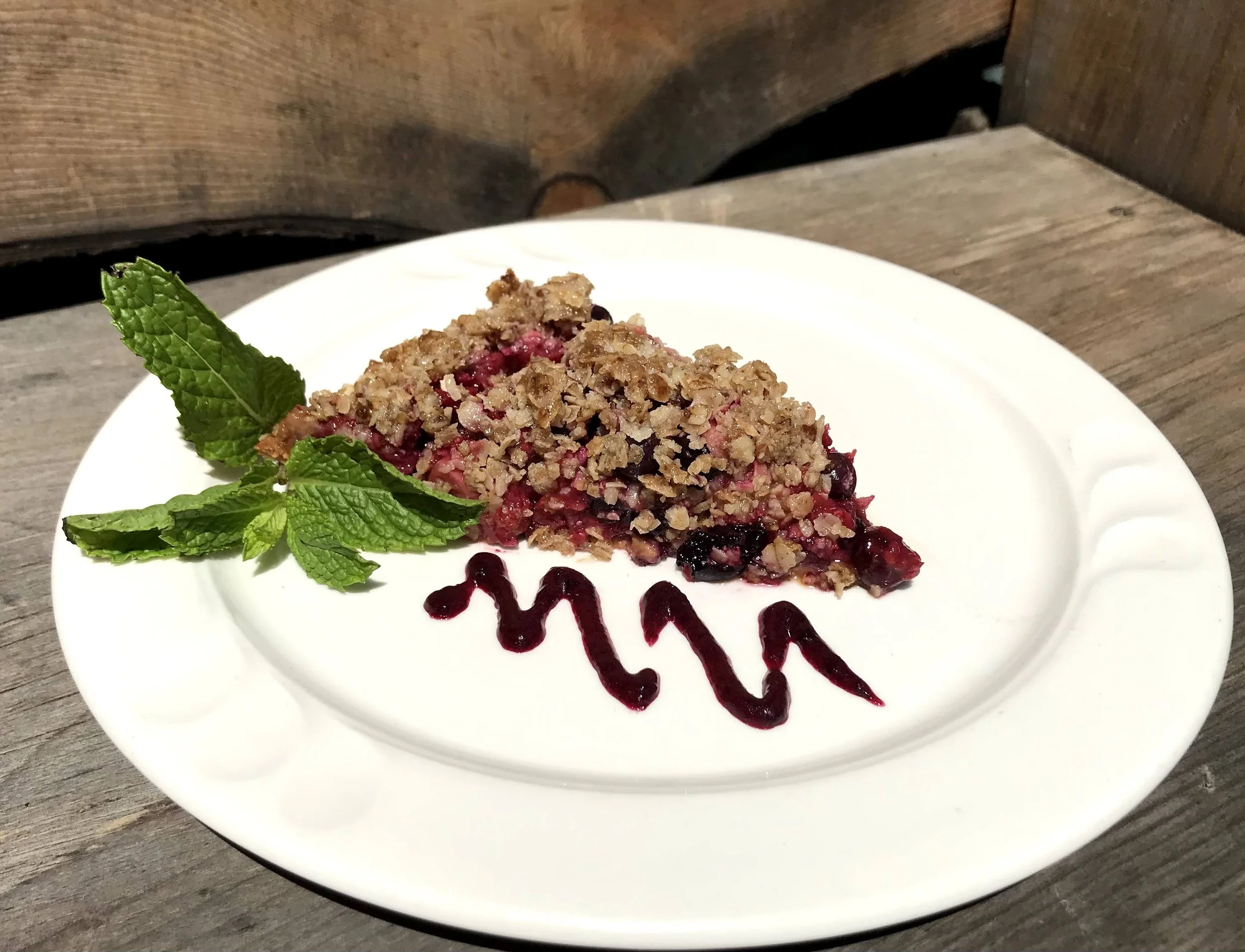 Vegan Tripple Berry Crumble Pie with homemade black raspberry sauce