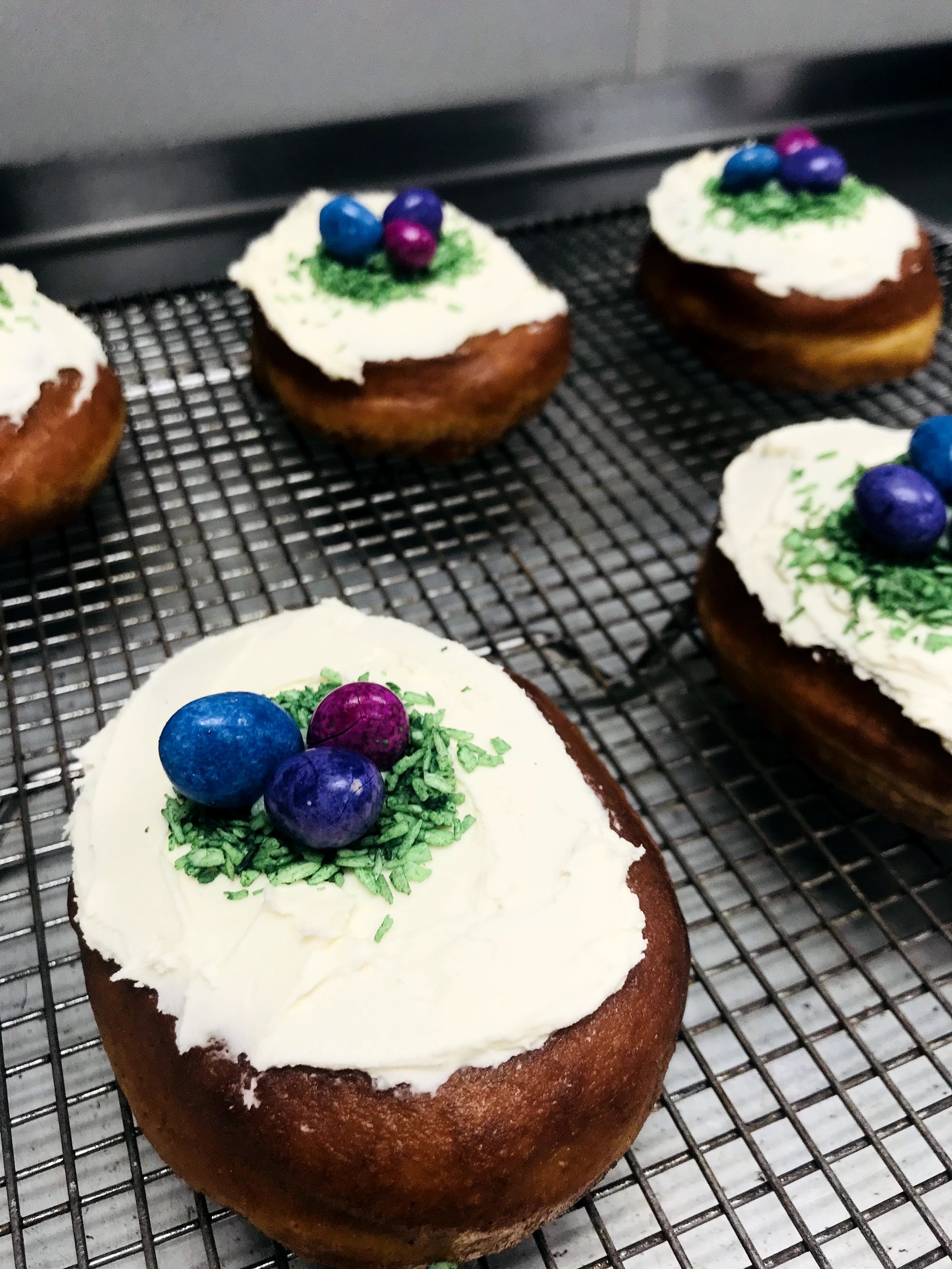 Vegan Easter Doughnuts with vanilla frosting, sanding sugar, & candy eggs