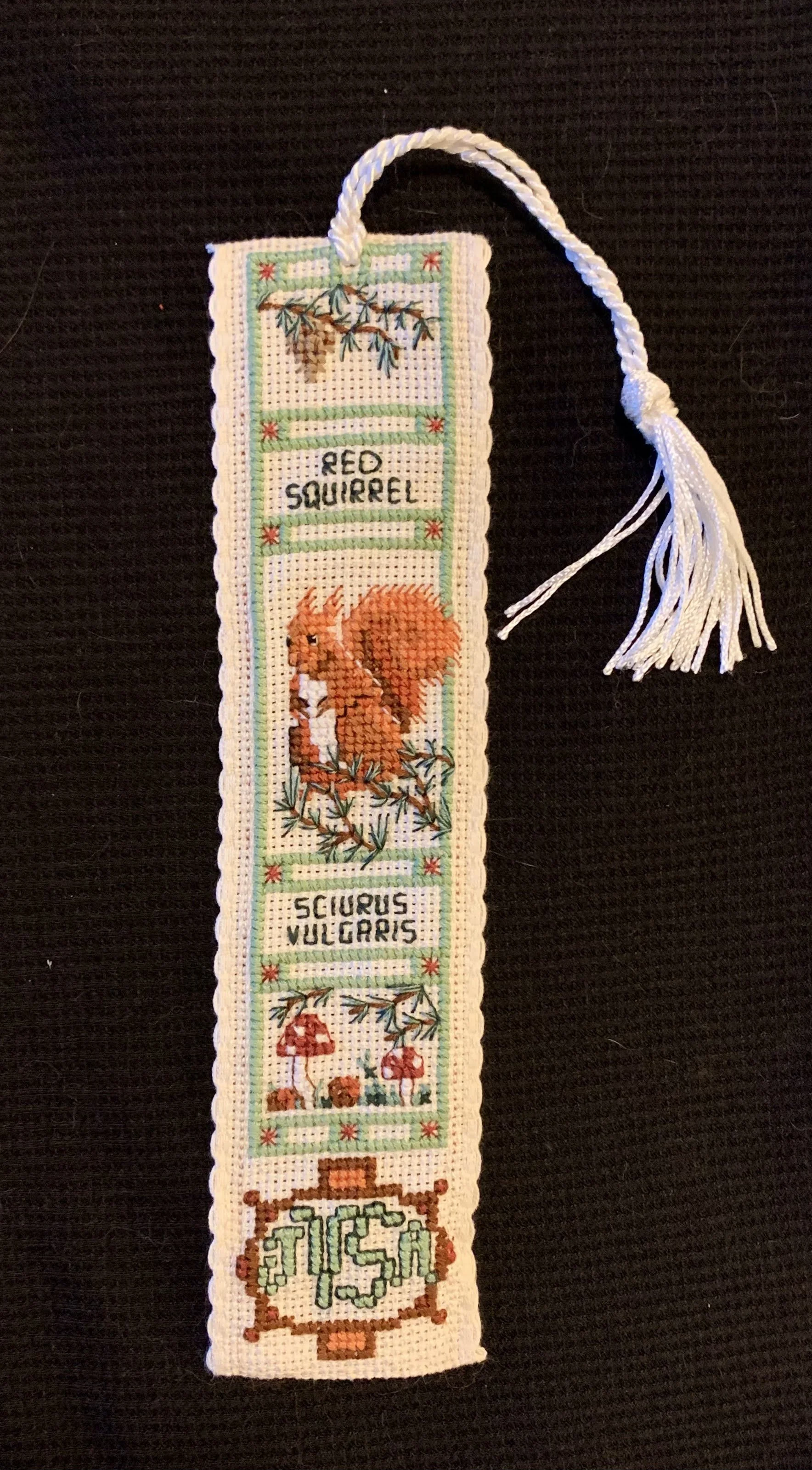Red Squirrel Monogrammed Bookmark, 2023, cotton thread on aida with polyester tassel and felt backing.