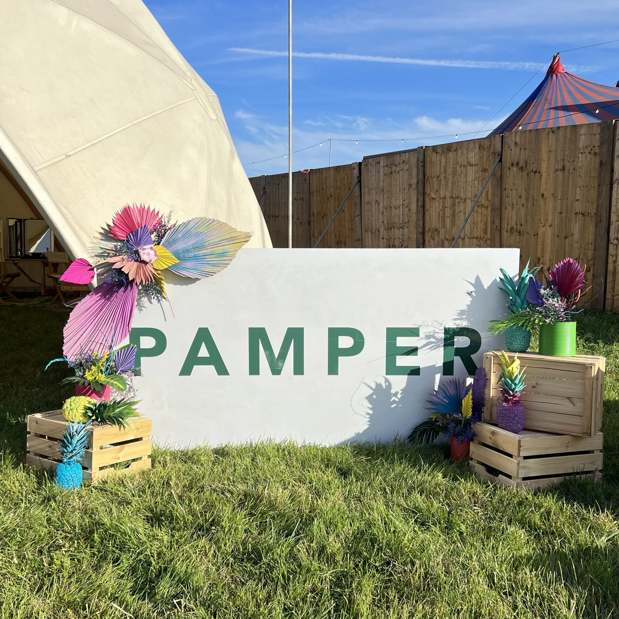 Green and colourful festival sign that say's 'PAMPER'