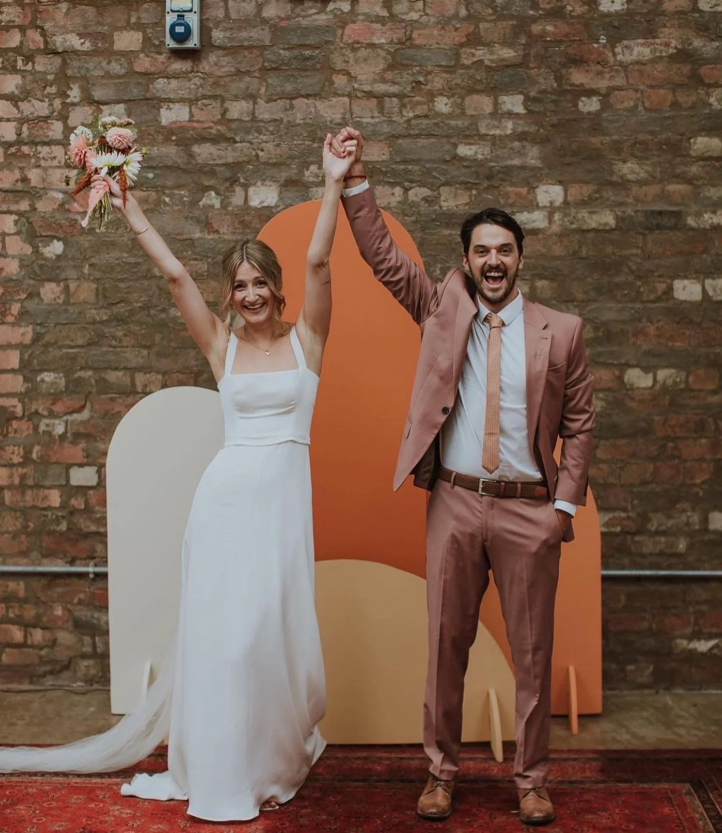 Married couple at warehouse ceremony with abstract backdrop