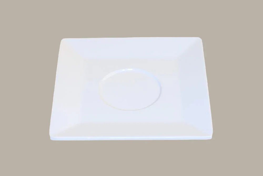 Wit vierkantig bord met ronde insert, op een beige achtergrond.