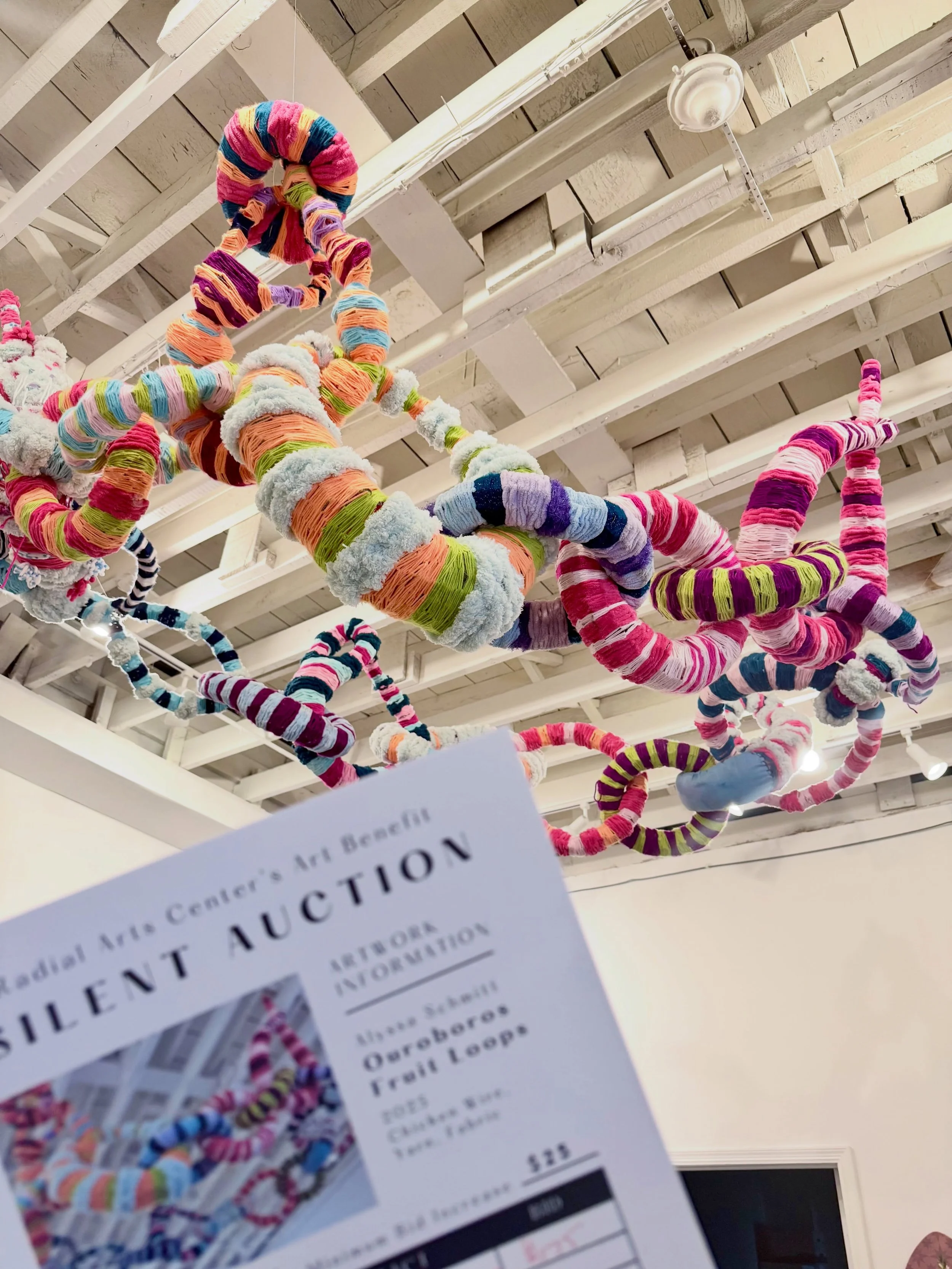 &ldquo;Ouroboros Fruit Loops&rdquo; by Alyssa Schmitt @paintlegs is still available via silent auction!  This whimsical fiber/ mixed media sculpture can transform your space and bring color &amp; wonder to any room!  Play room? Waiting room? Child&rs