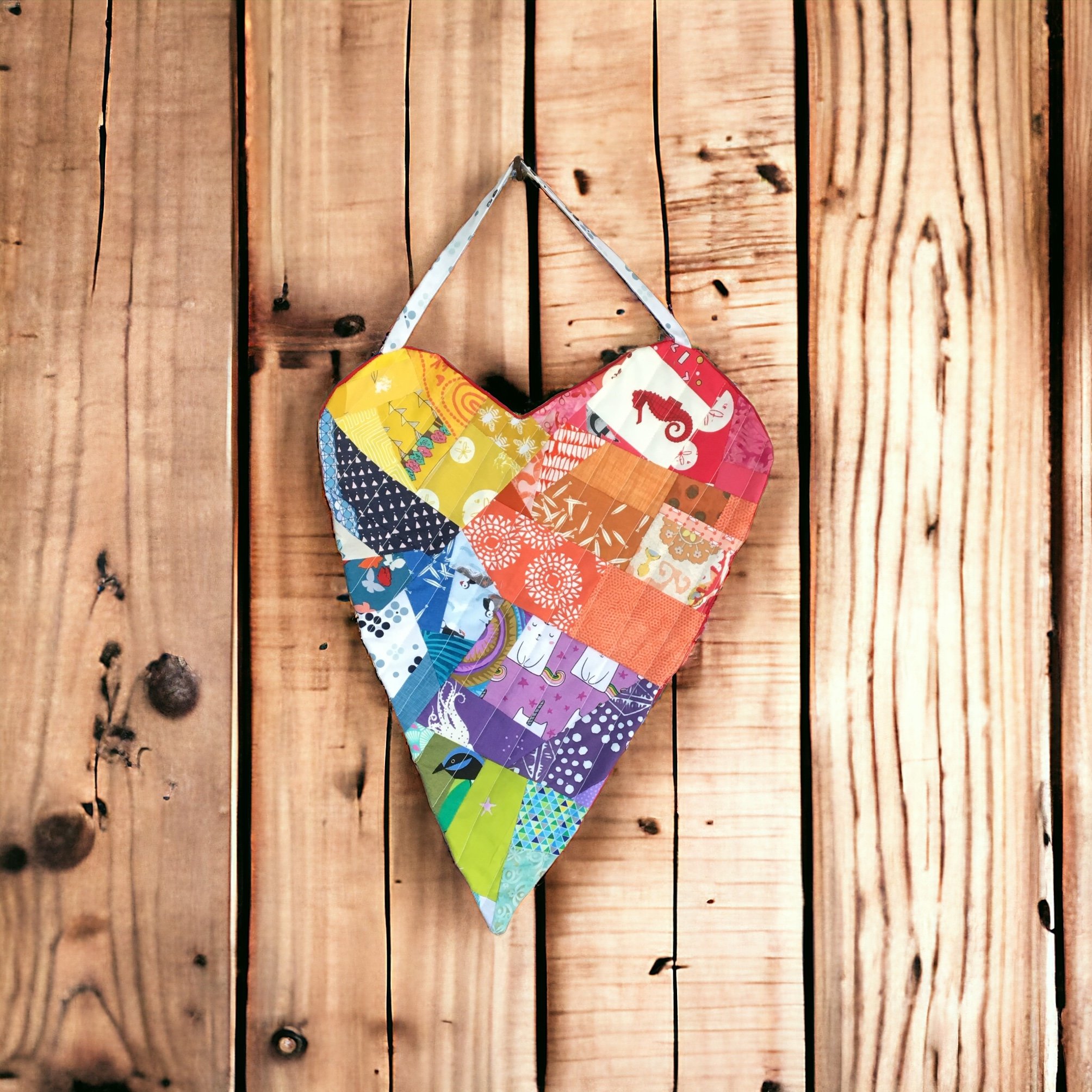 This is a large rainbow patchwork heart meant to hang inside or outside (under cover) to spread love and cheer.