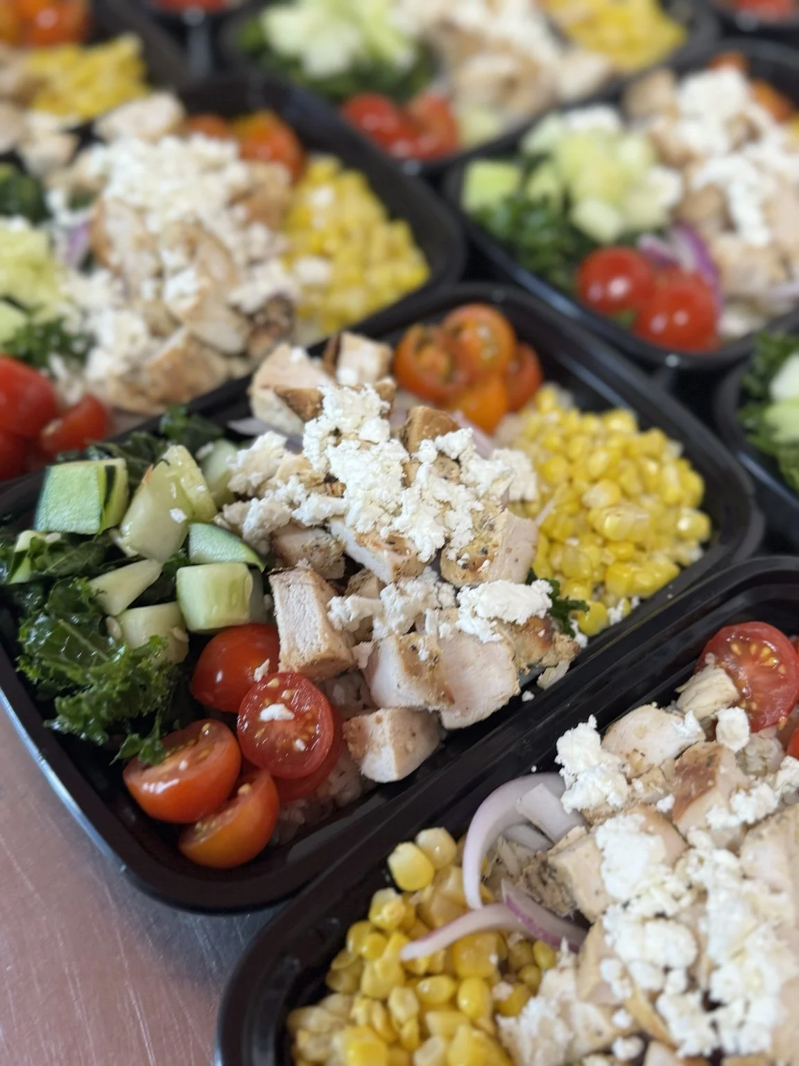 Chicken bowls with corn, cucumber, tomatoes and crumbled cheese.