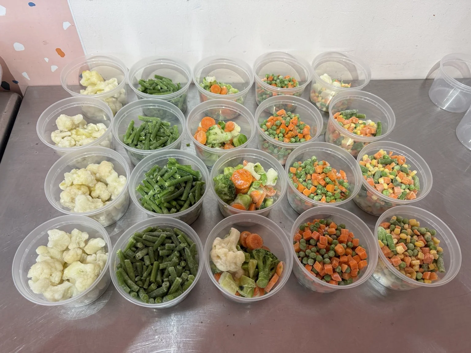 Cauliflower, green beans and mixed vegetables portioned in containers.