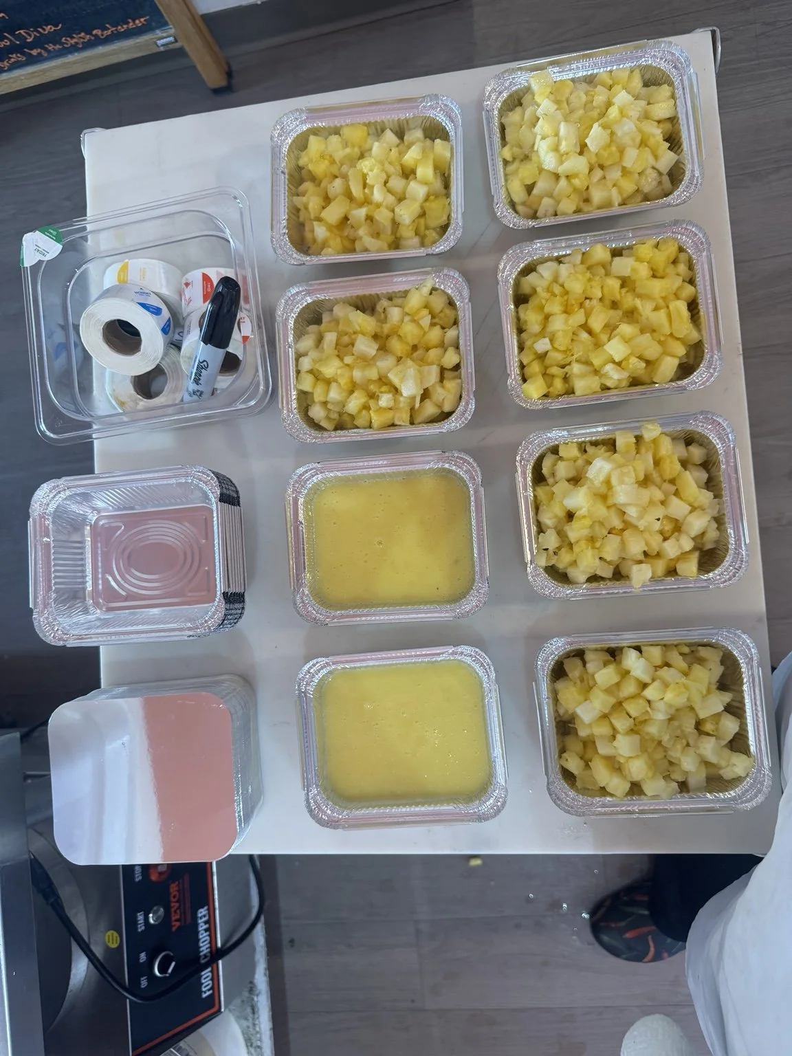 Pineapple portions prepared in trays for meal service.