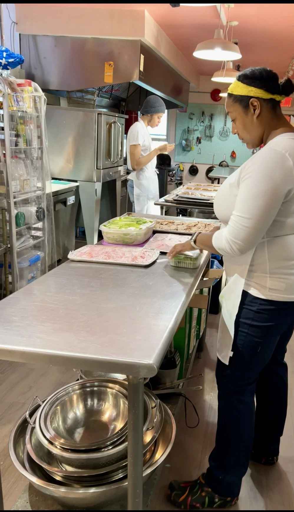 Founder Cassie Dadzie preparing food with her team inside a commercial kitchen.