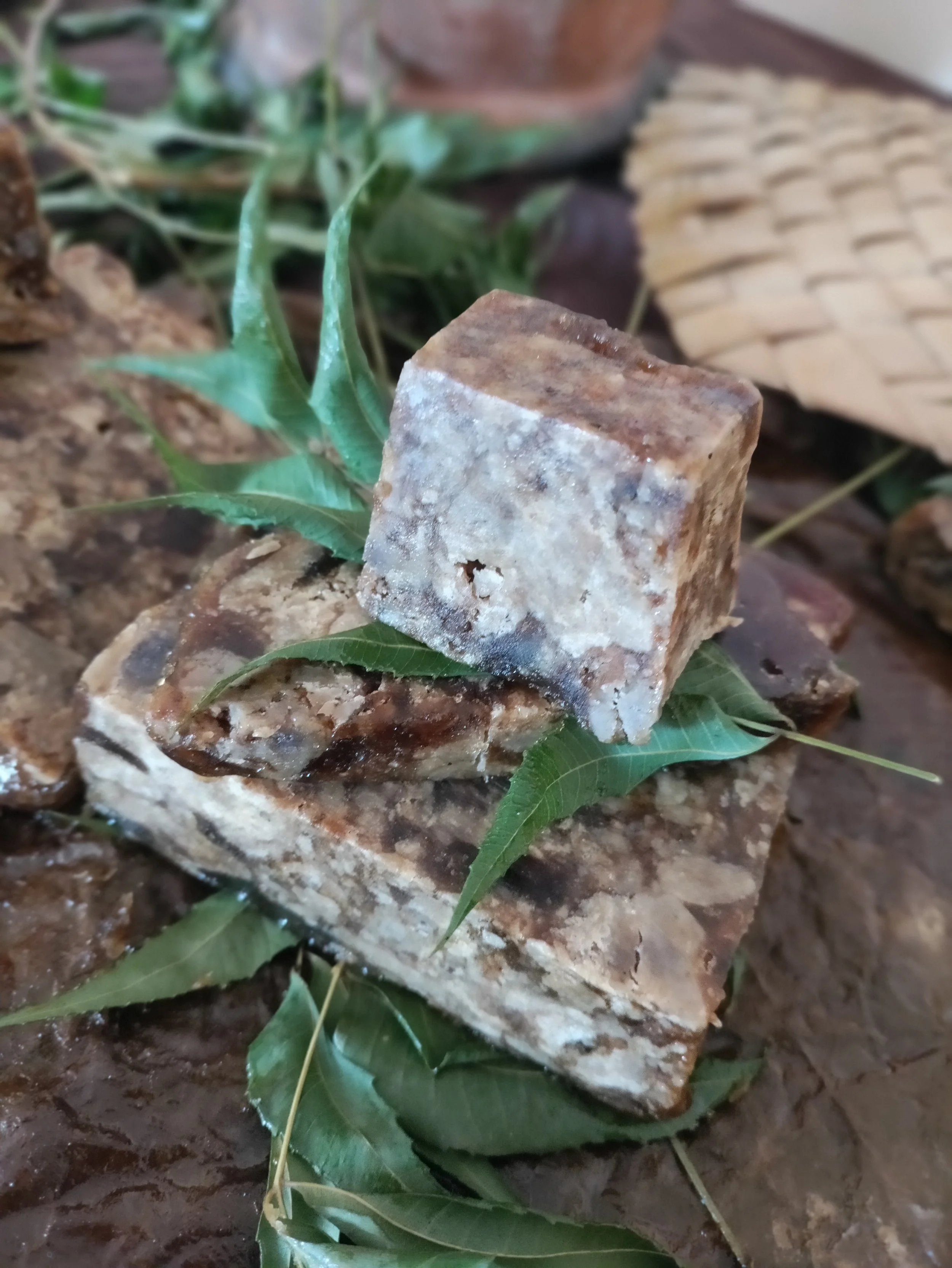 Natural soap bars stacked with green leaves.