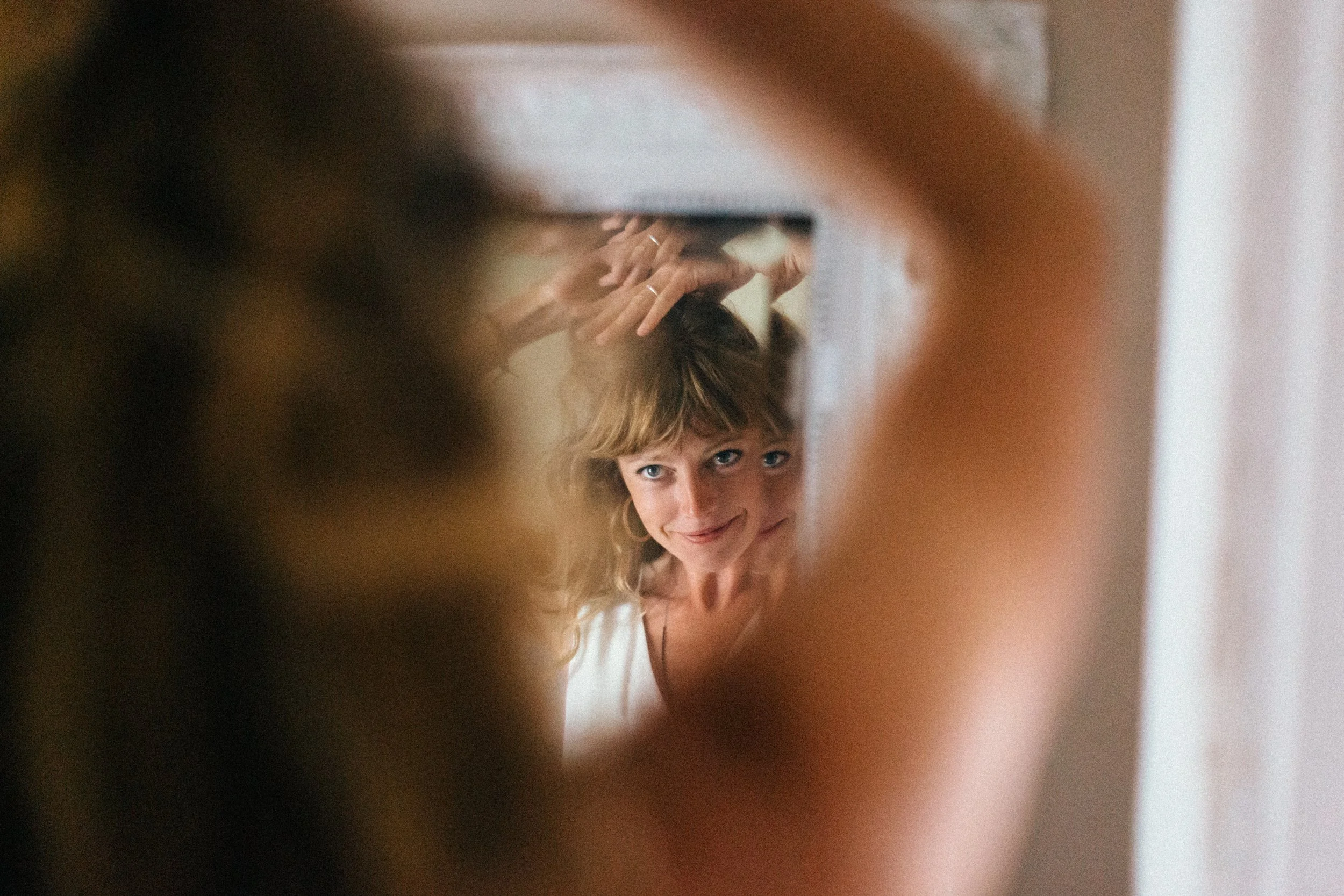 a red haired bridesmaid looking in to a mirror