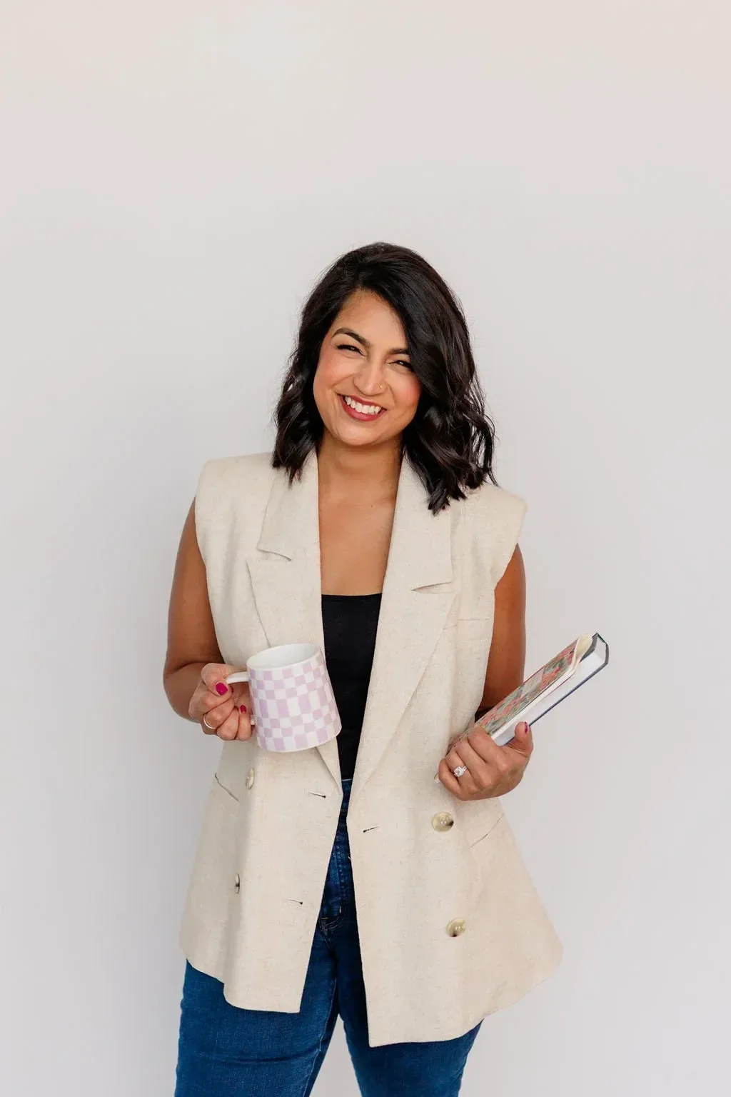 Image of Priyanka Rao holding a book while seated ADHD Coach Asha Coaching & Consulting
