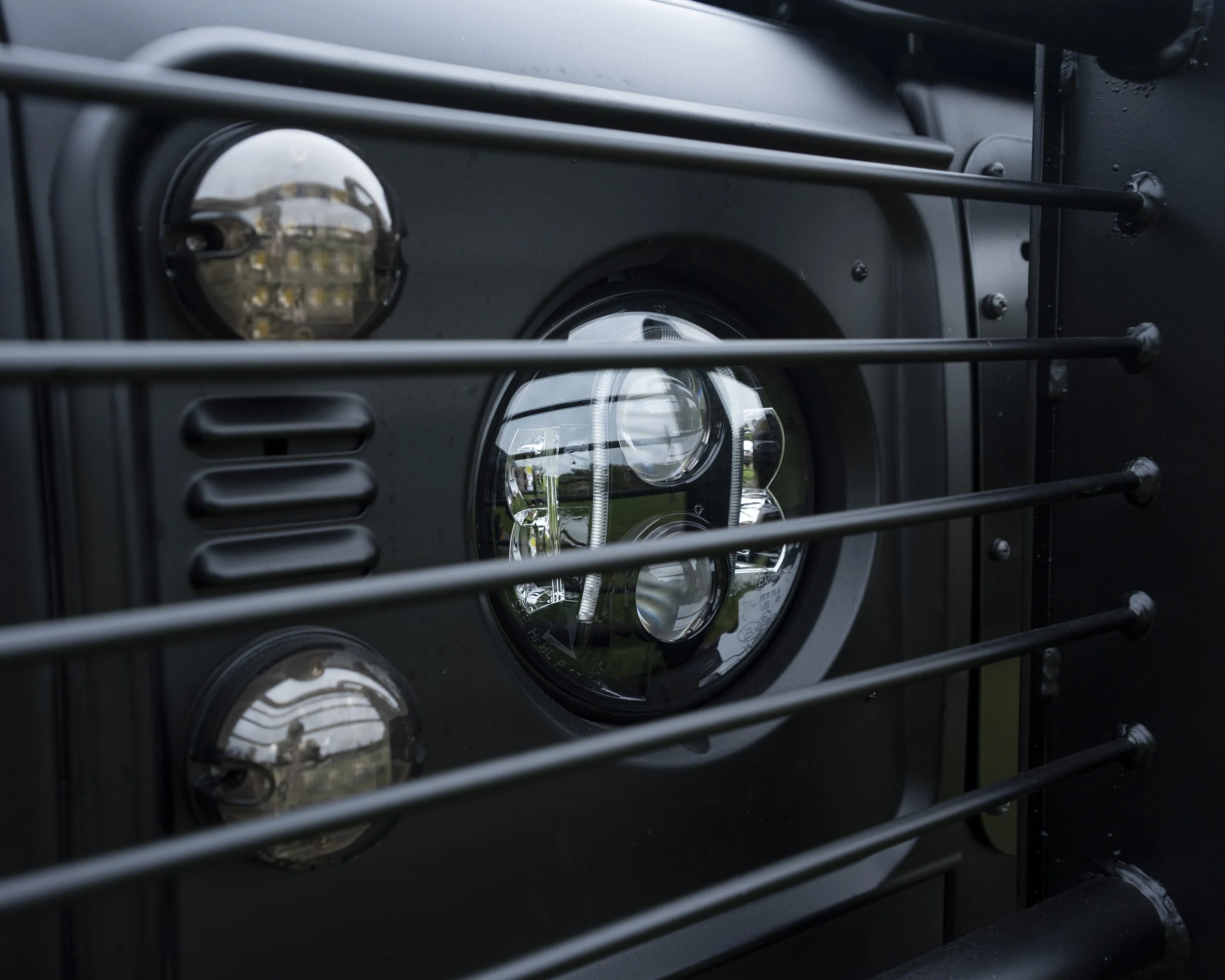 Close-up of a black electric grill with the heating elements and LED lights visible behind metal bars.