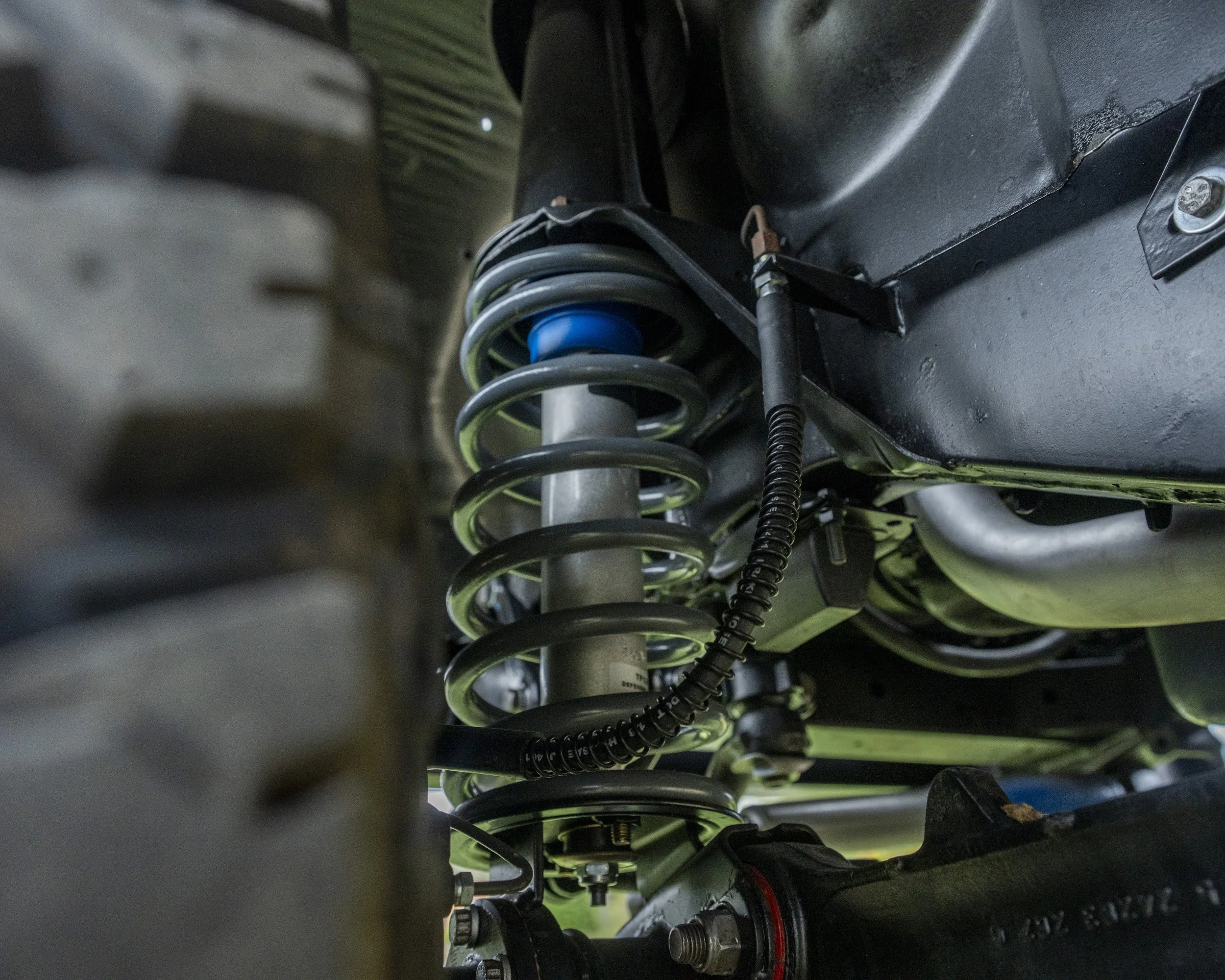 Close-up of a vehicle suspension system with coil spring and shock absorber.