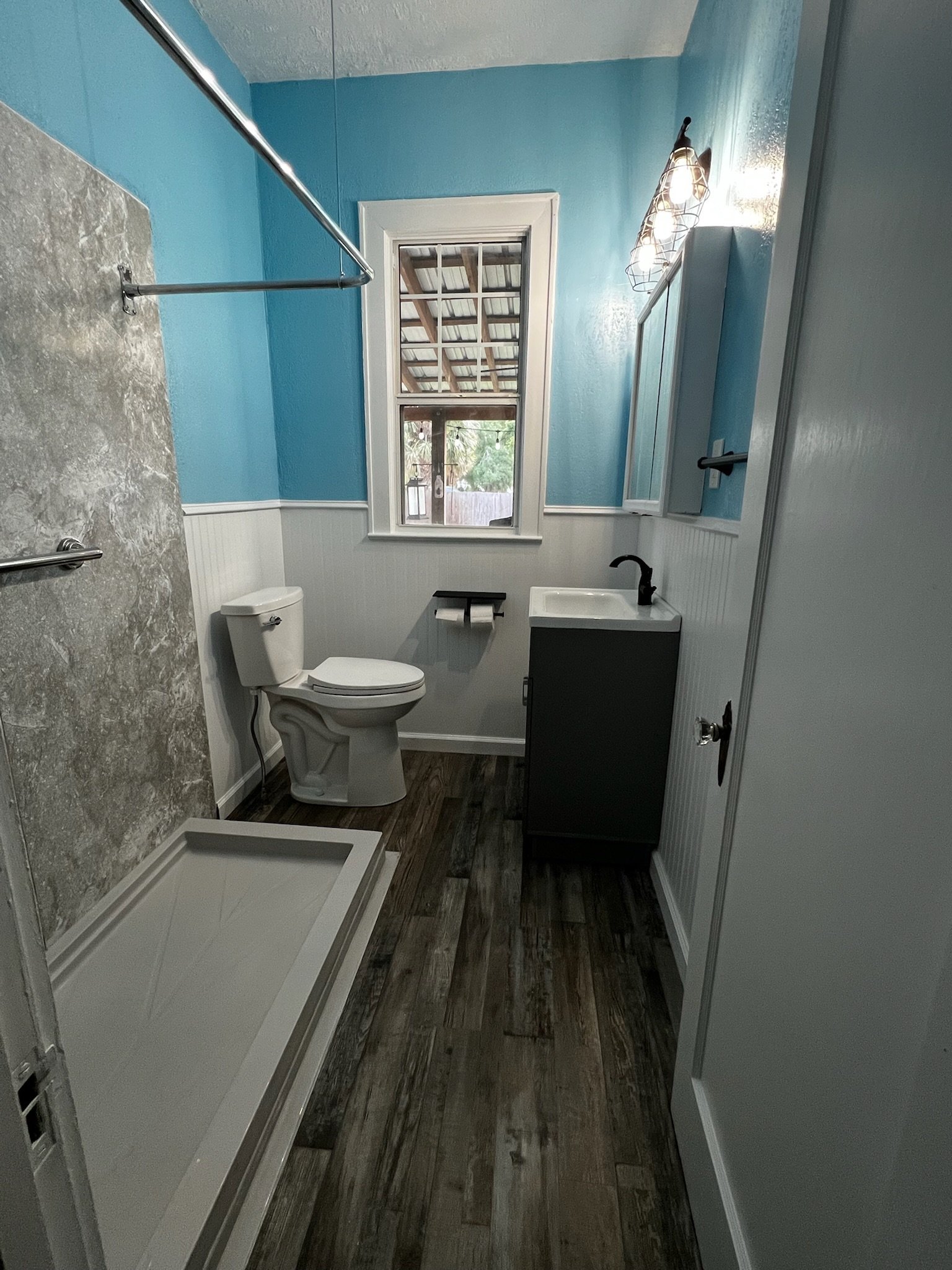 After- New LVP flooring, fixtures, sheetrock, beadboard wainscotting, and paint.