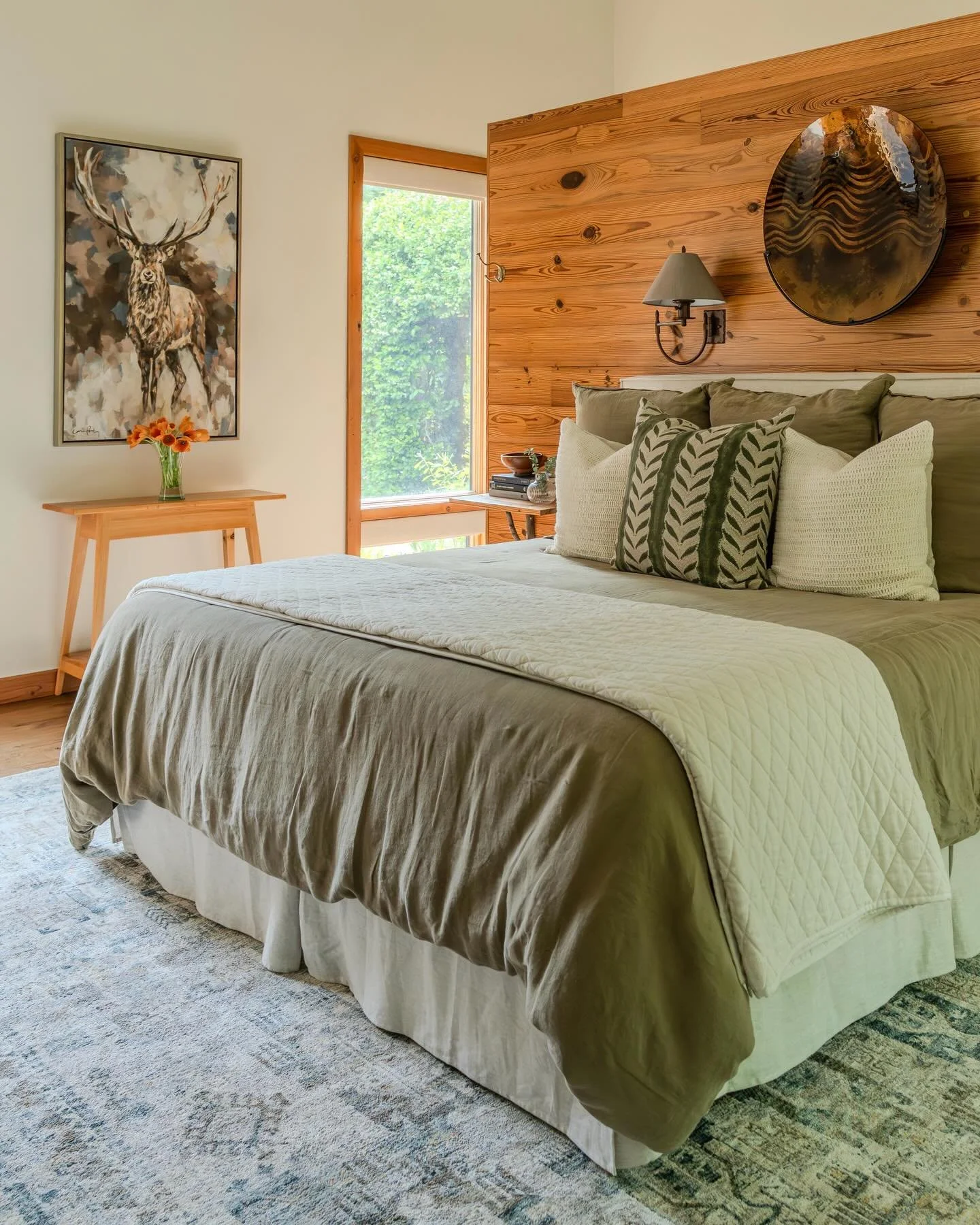 Linen and layered. This serene primary bedroom welcomes natural light from every angle. Neutral linen bedding, paired with artwork by @carriepenleyart and grounded by a rug from @loloirugs , creates a warm and inviting retreat.