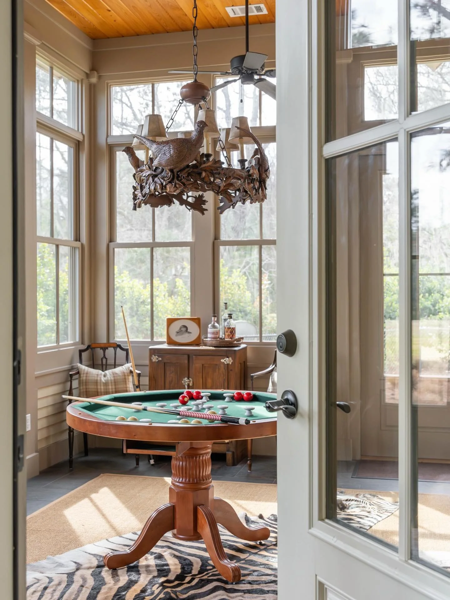 Stay awhile. This cozy game room is ideal for game nights and extra seating during meals. The carved pheasant chandlier by OK Castings is a highlight of the space.