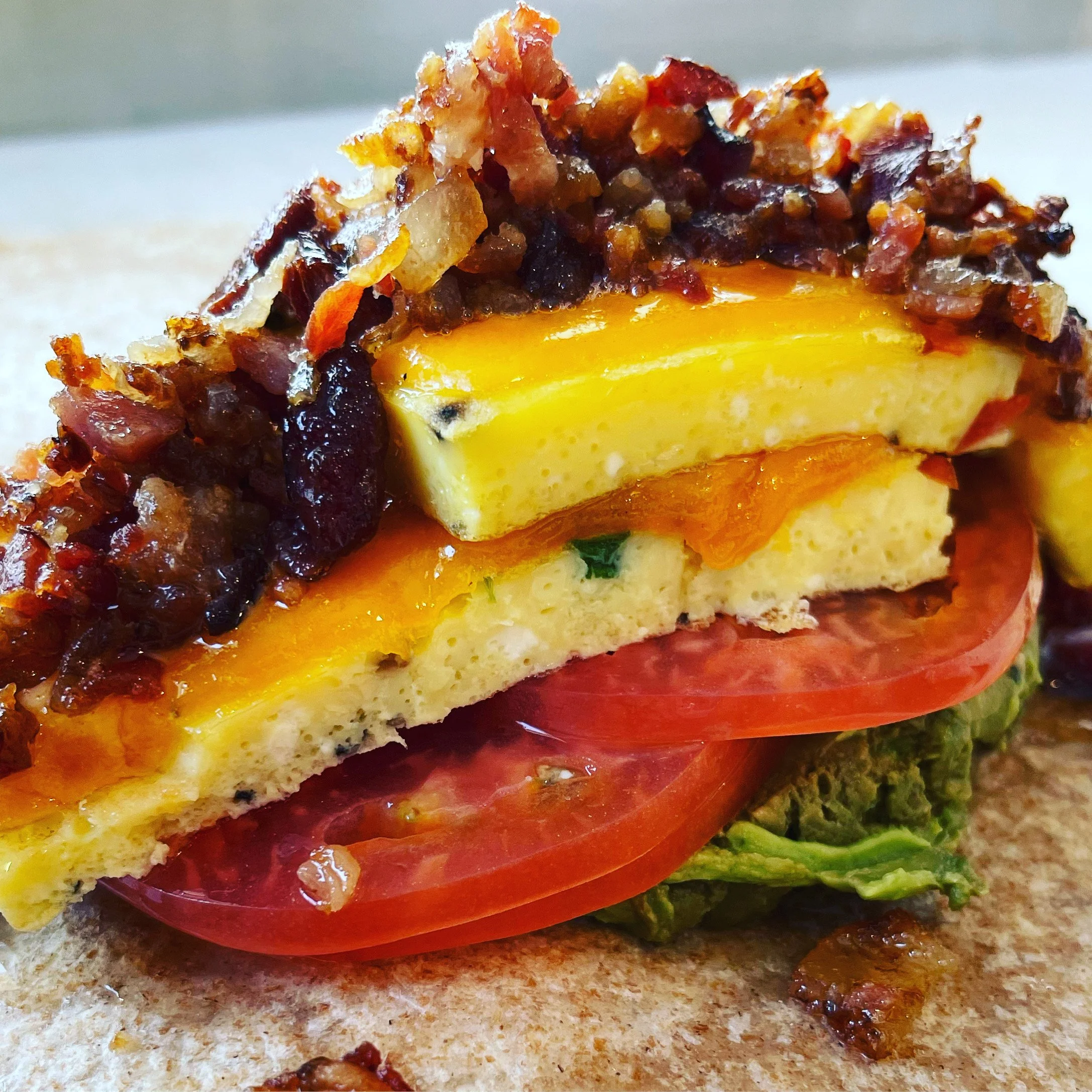 Tomato, egg, cheese and bacon piled on a wholewheat wrap