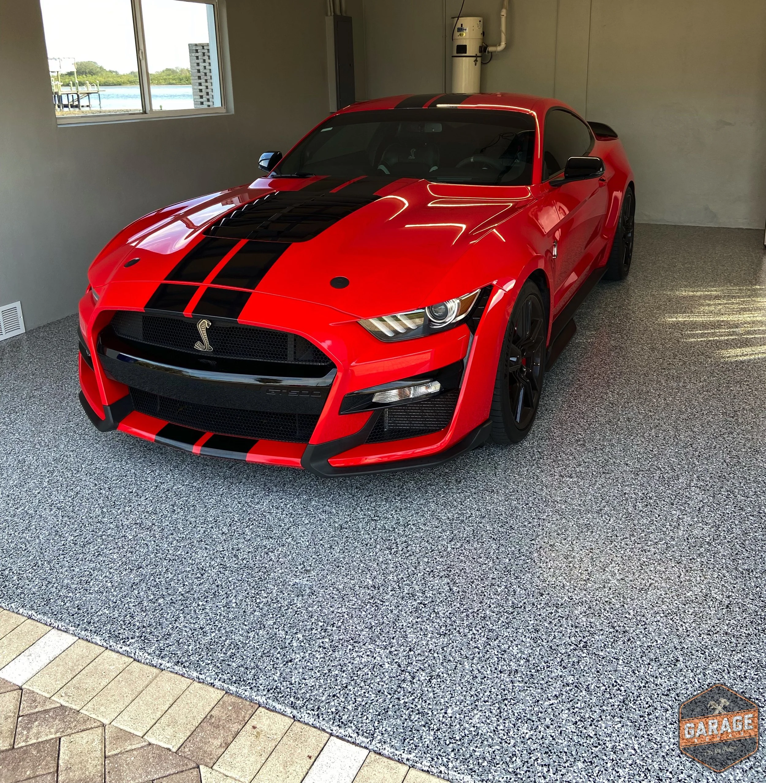 Garage floor with tuxedo epoxy with a sports car parked inside