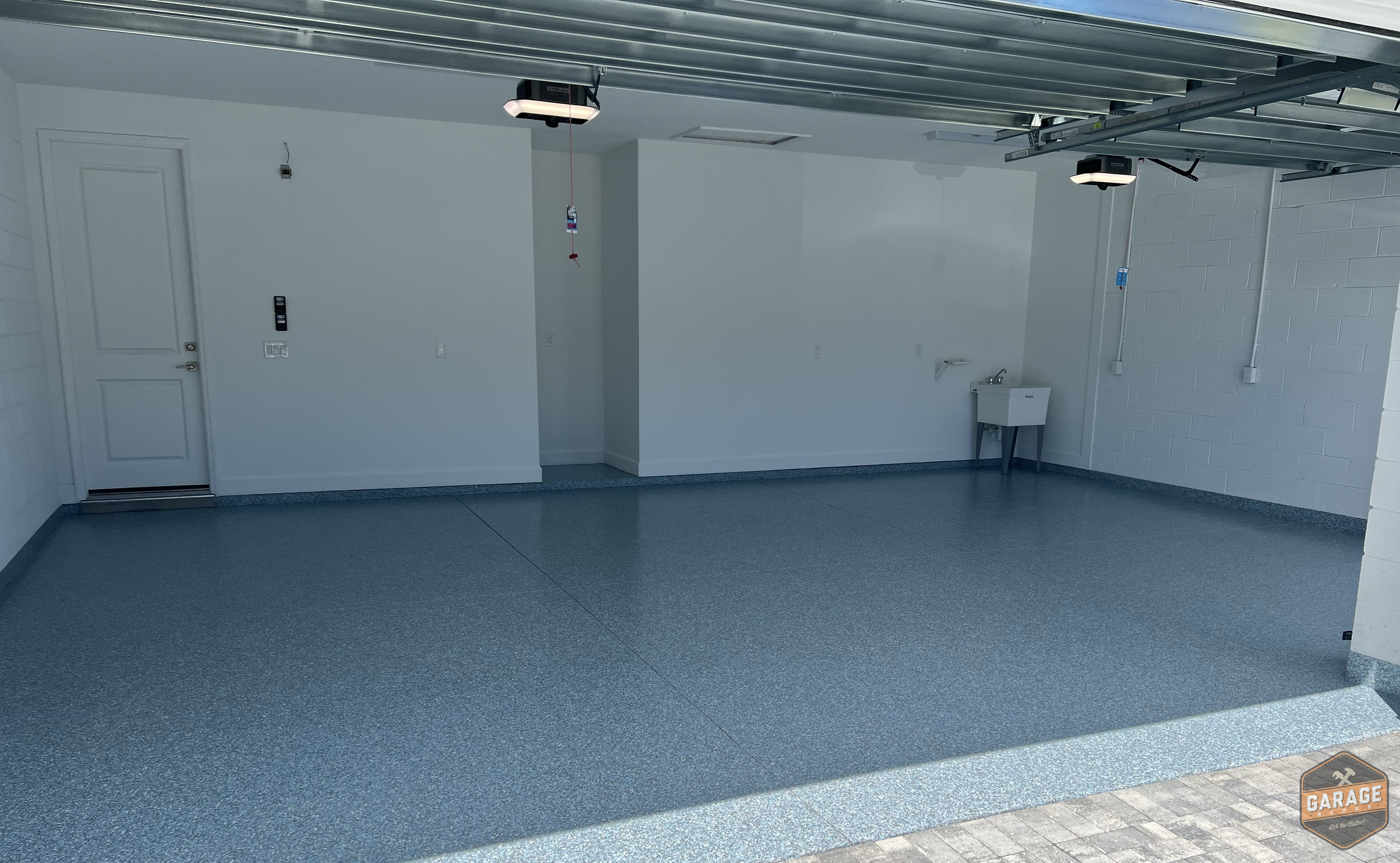 A three car concrete garage floor with blue epoxy aspartic floor coating