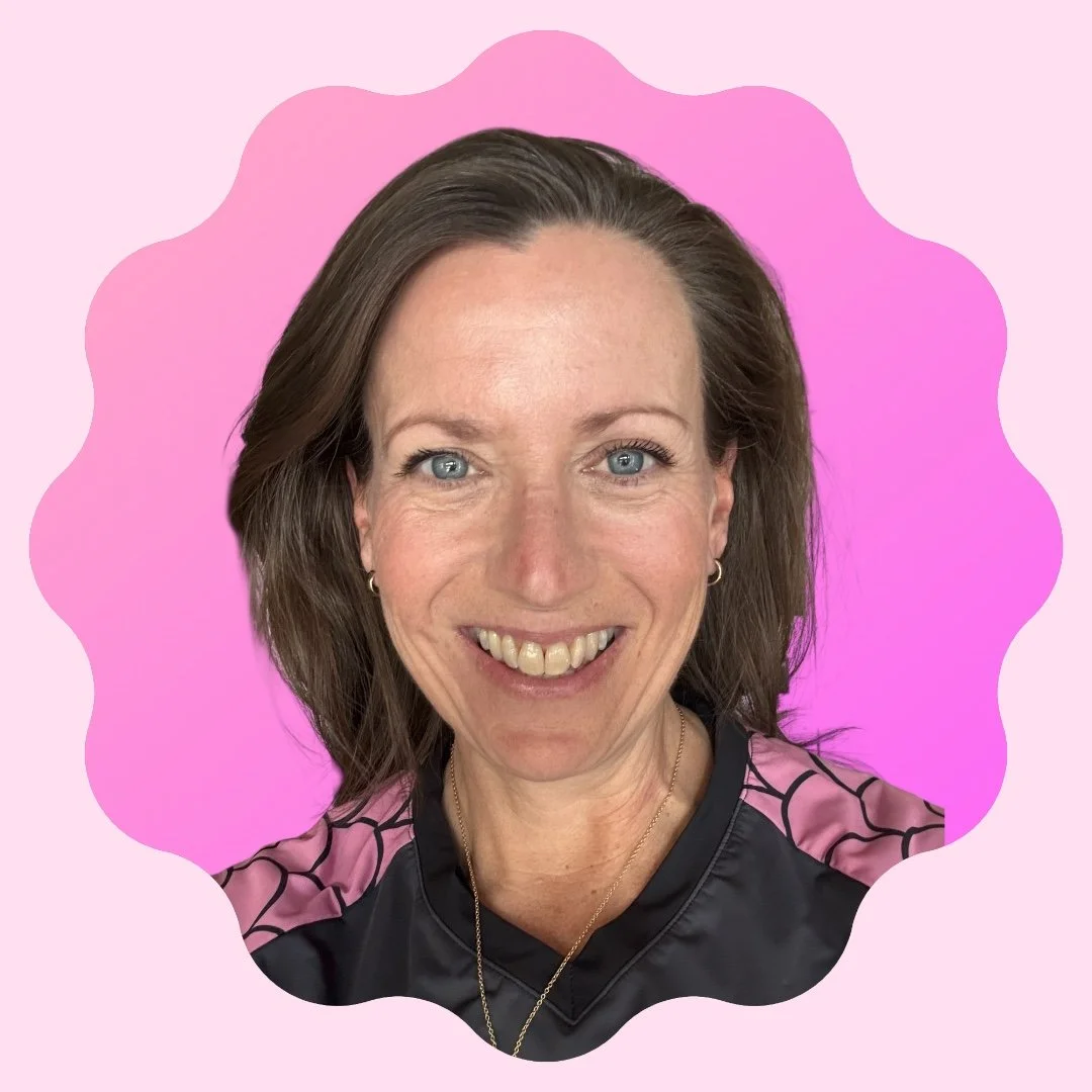 A woman with short gray hair smiling, wearing a black and pink sports top with a pink pattern, against a pink background.