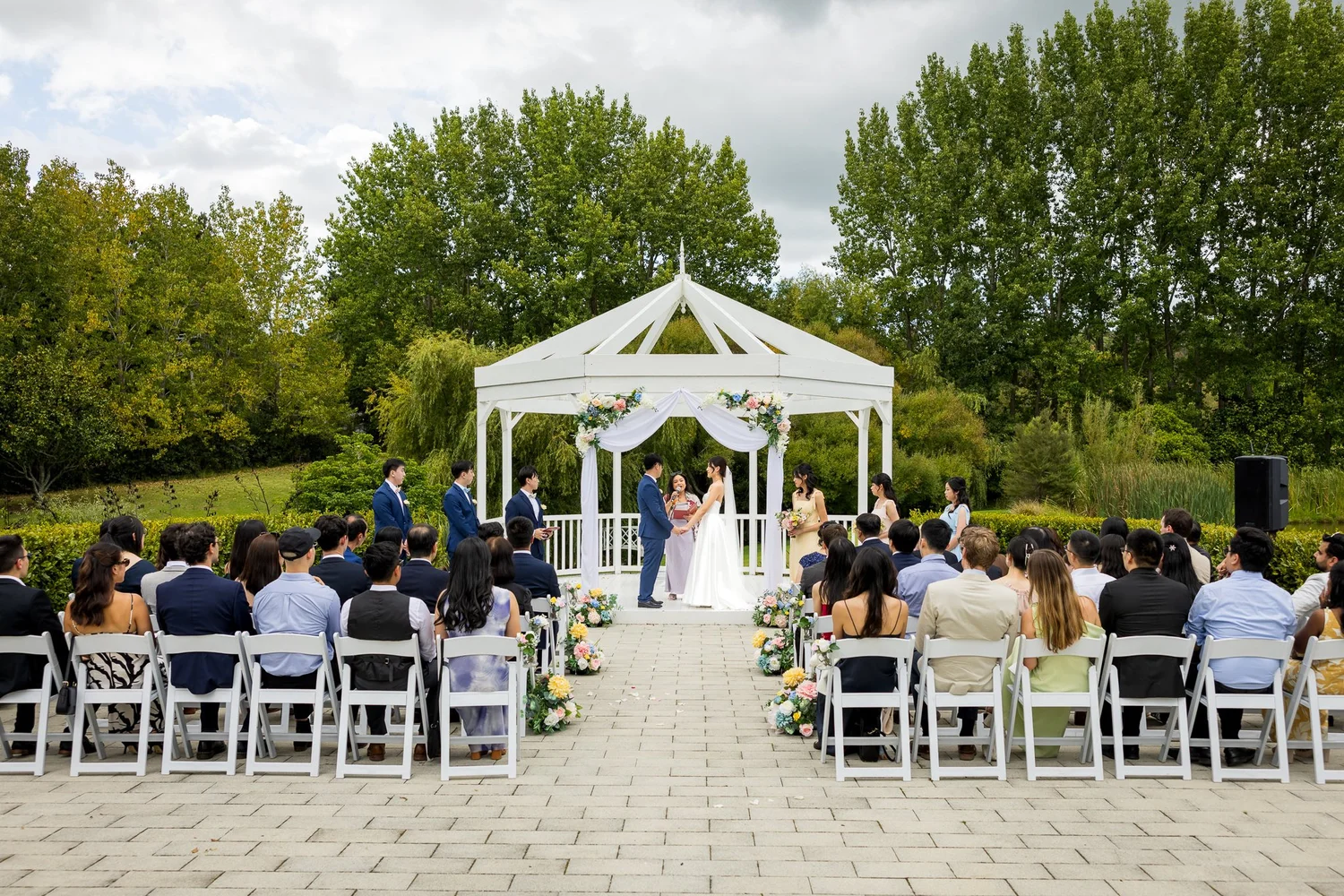 Guests watch a garden ceremony at the gazebo at Abel Estate
