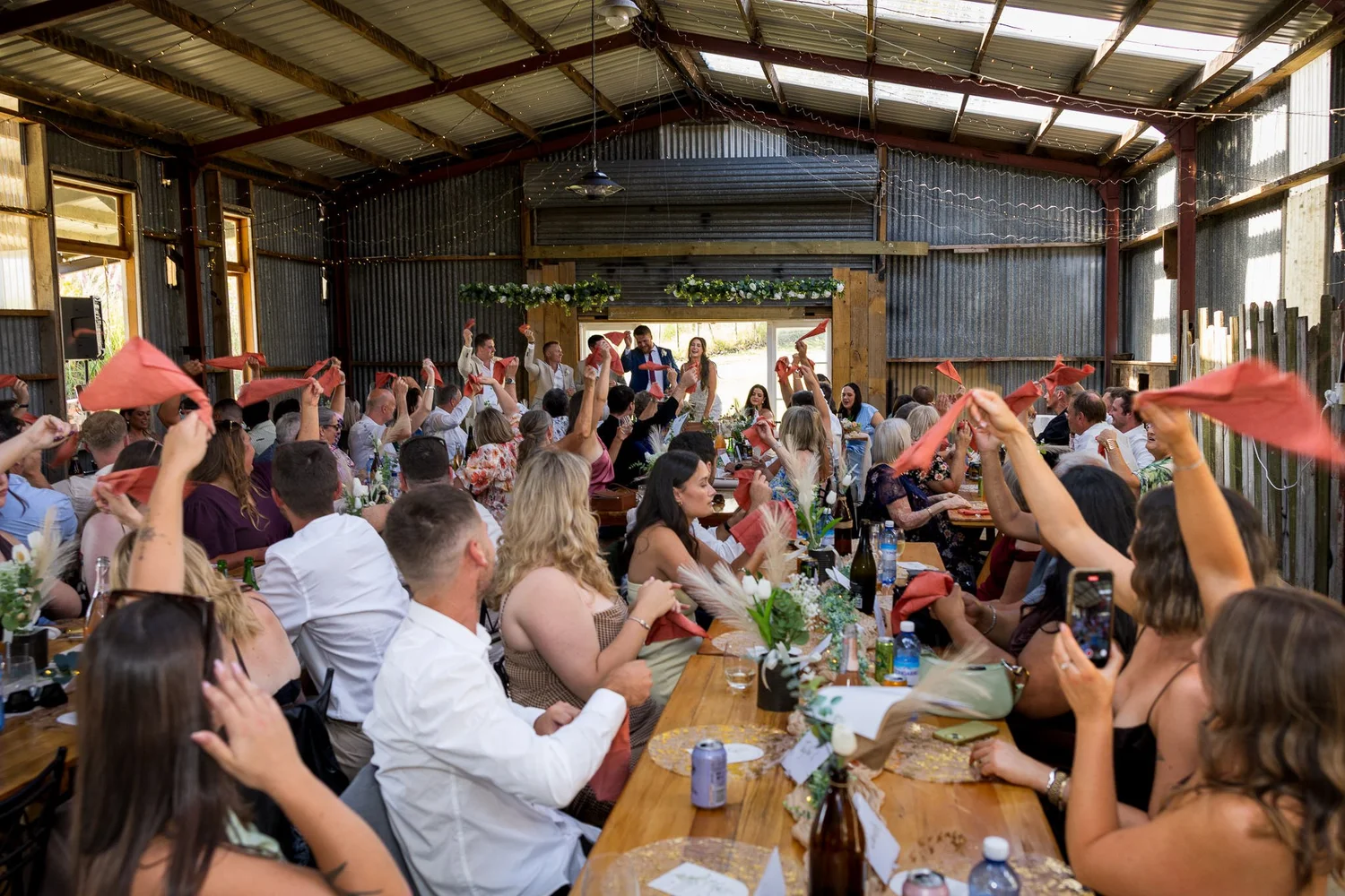 Guests wave napkins at the reception inside The Barn Waimauku