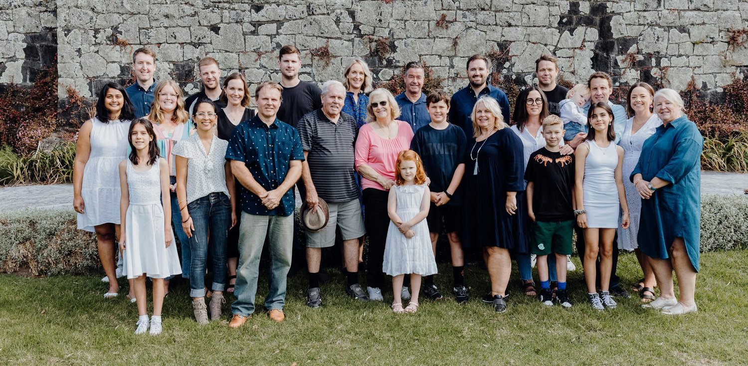 Dianne's extended family gathered for a group photo in front of a stone wall