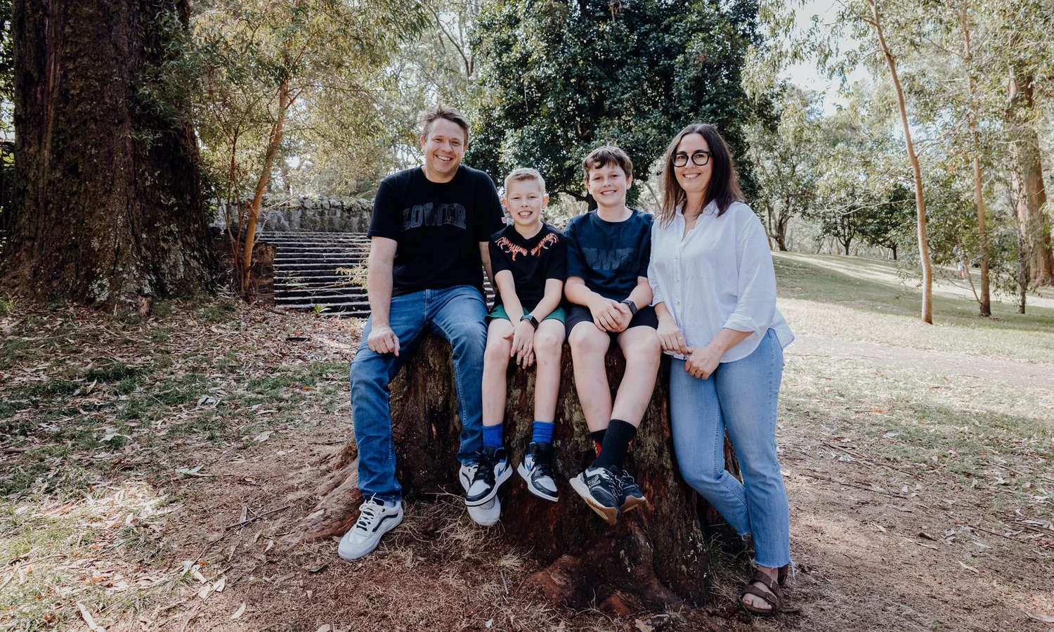 A family of four with a tree stump in the park