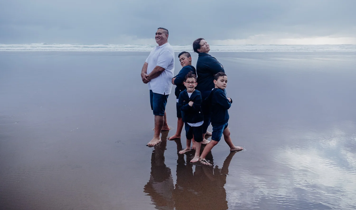 The family stands together on the beach on a misty day