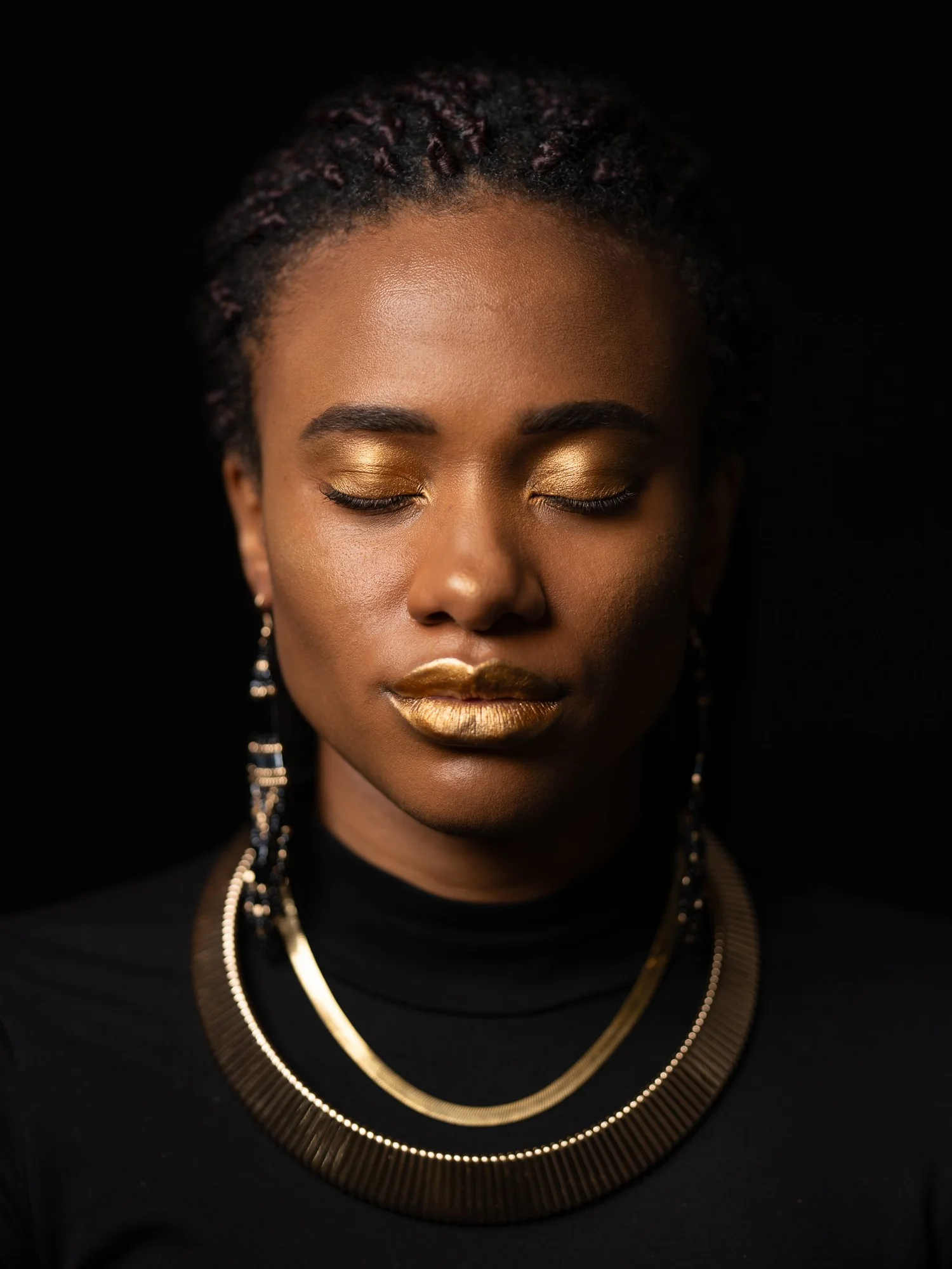 Ty with gold eyeshadow and a gold collar necklace