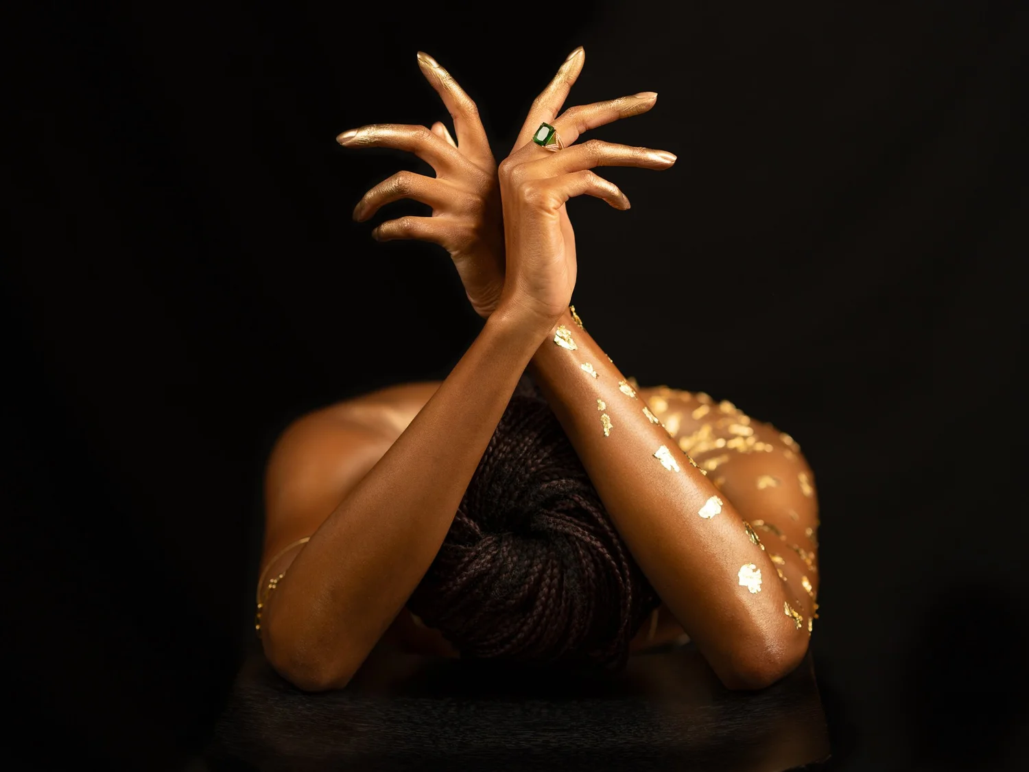 Ty's crossed arms covered in gold leaf
