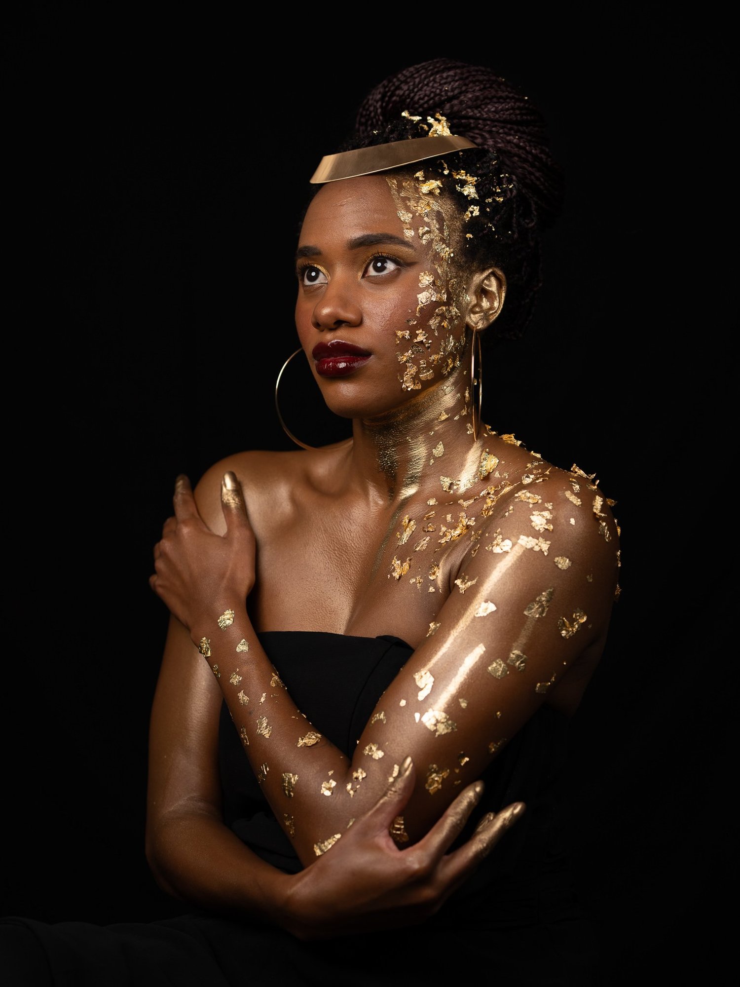 Ty hugs her gold-leafed shoulders in a studio portrait