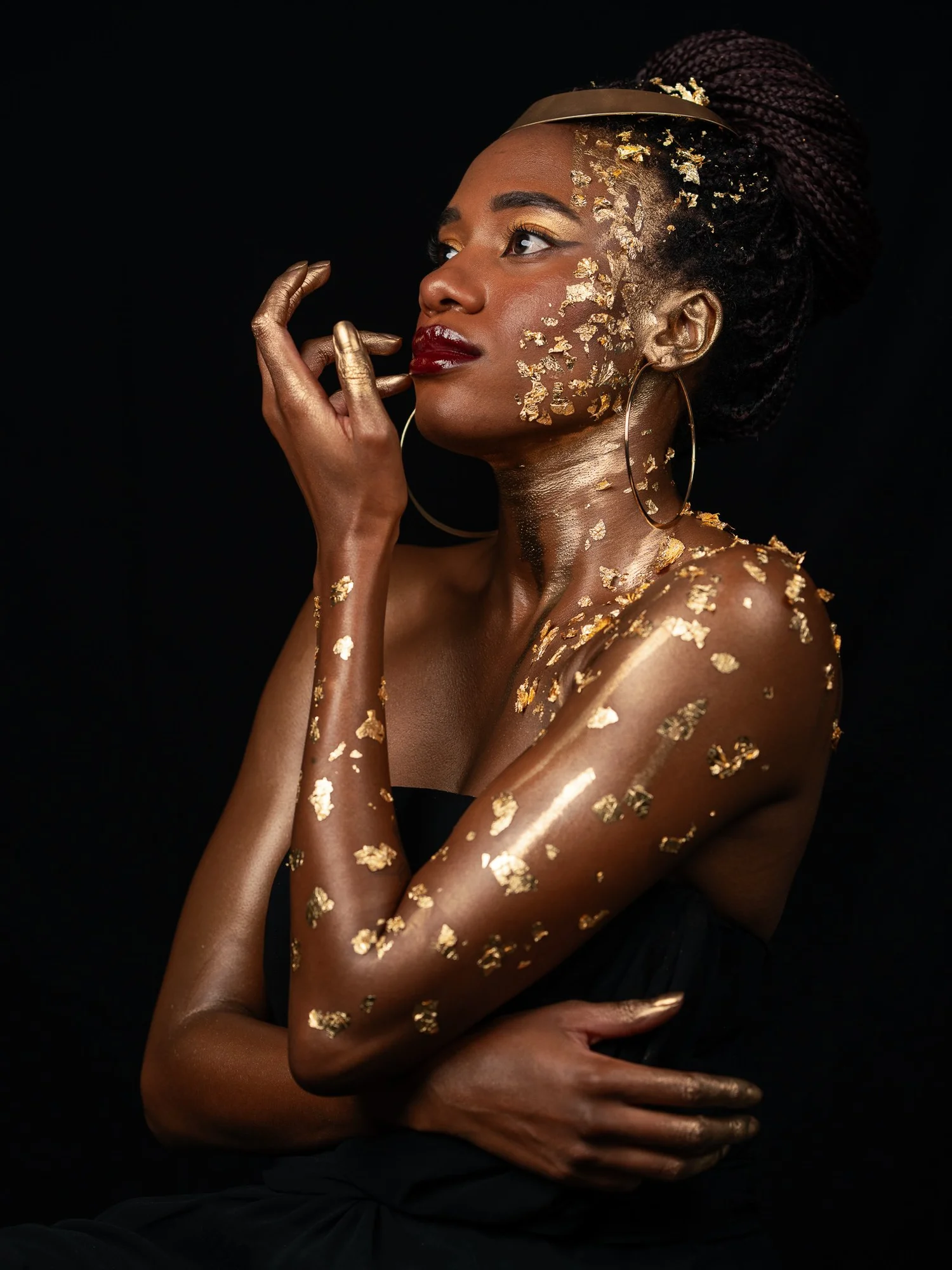 Ty in profile touching her gold-leafed face