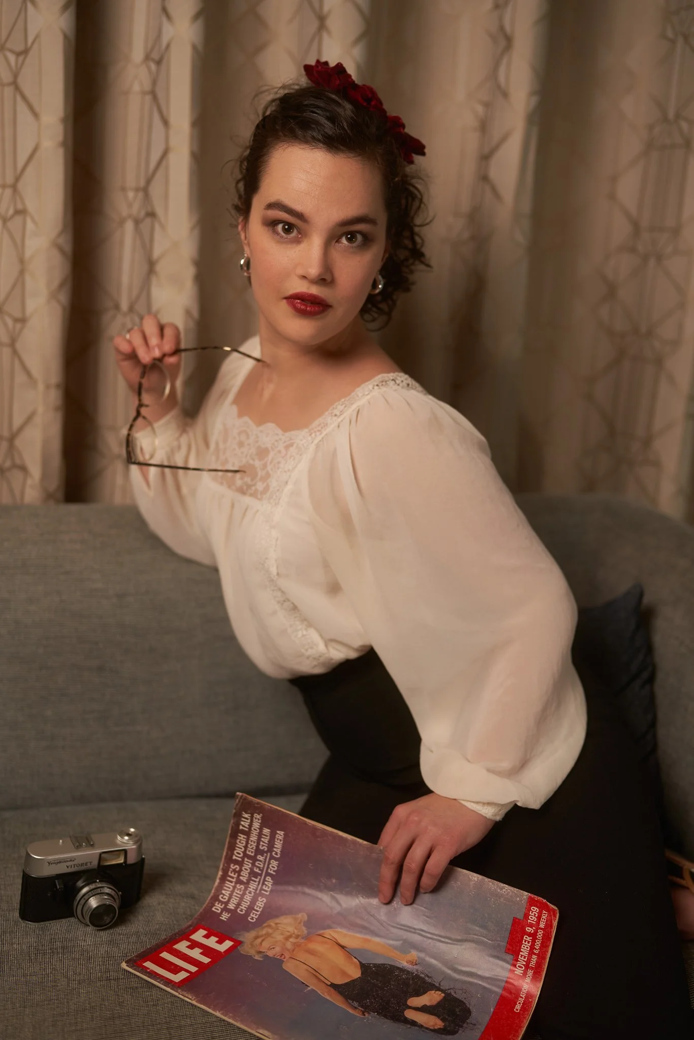 Anita in a white blouse with a camera and a LIFE magazine