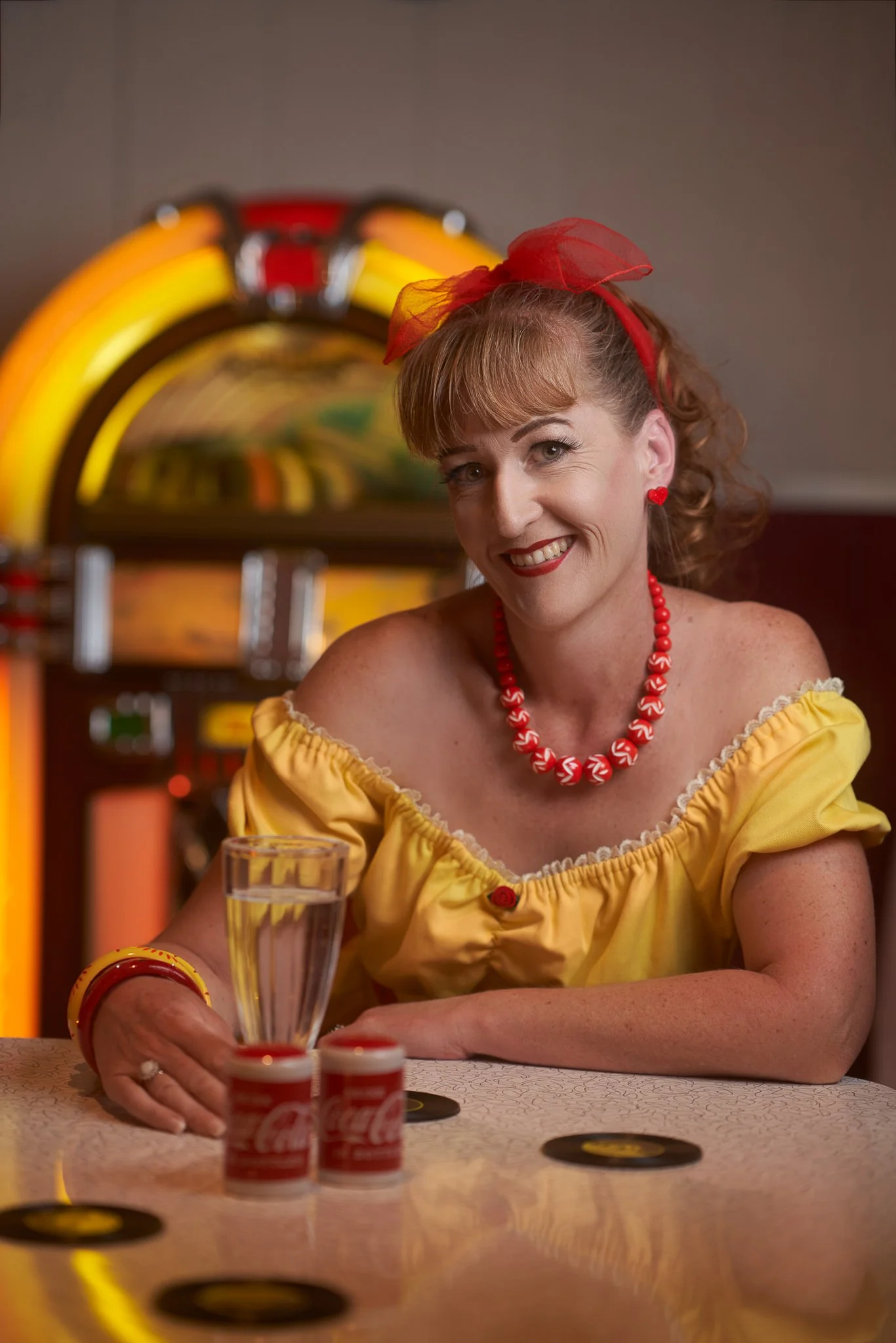 Sandy at the diner counter with a milkshake glass