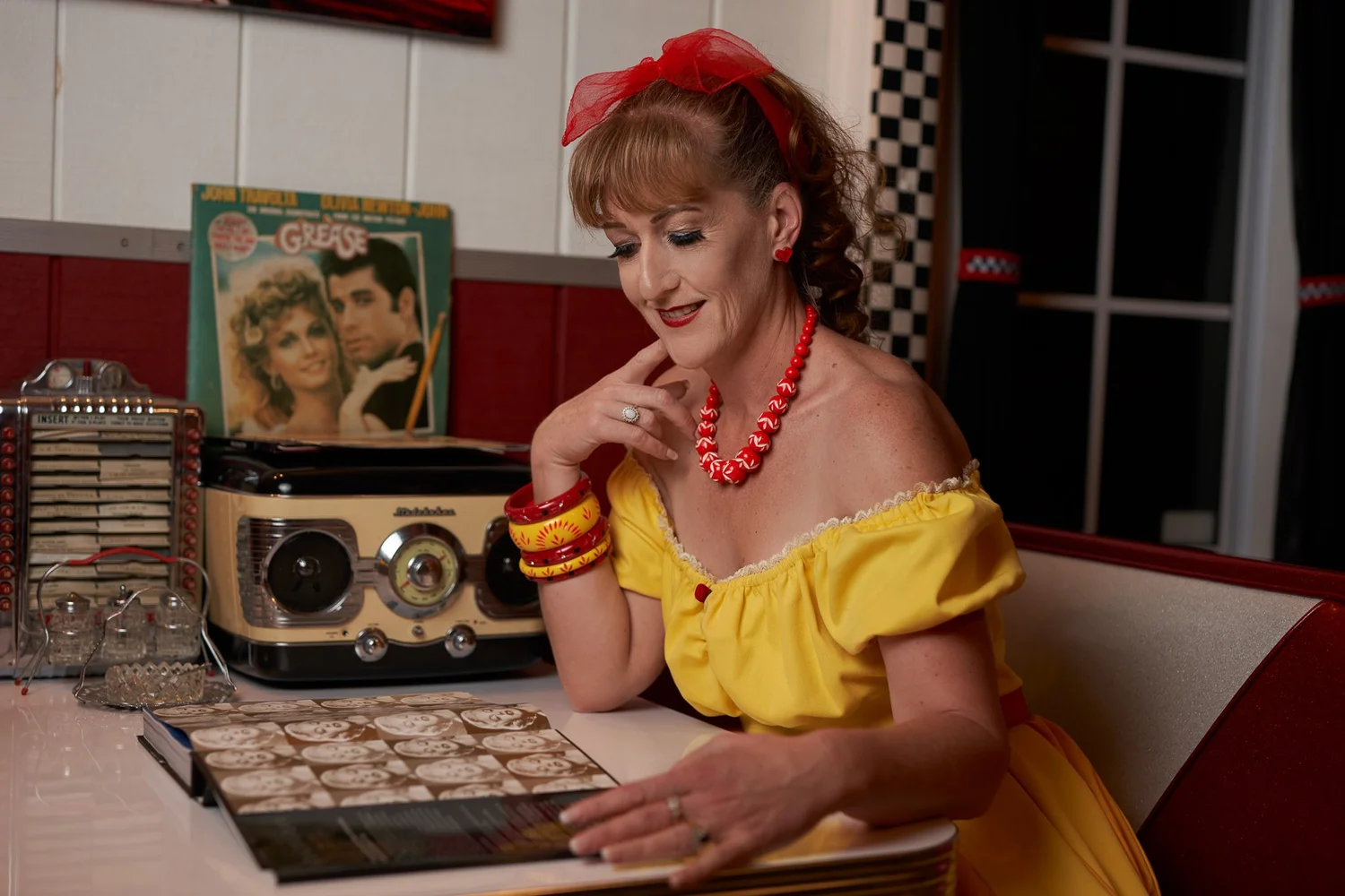 Sandy at a booth with a vintage radio and records