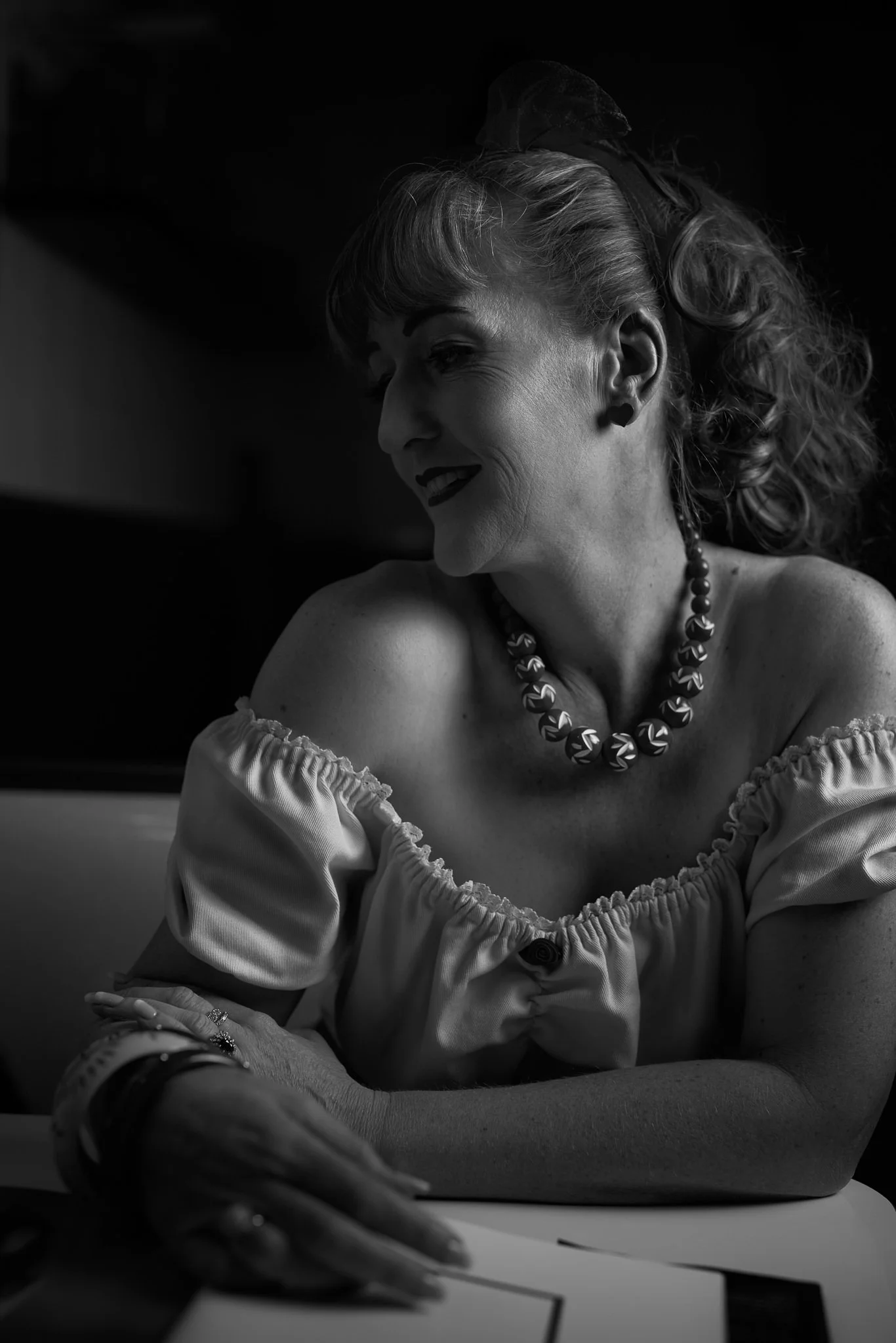 Black and white photo of Sandy leaning on the counter