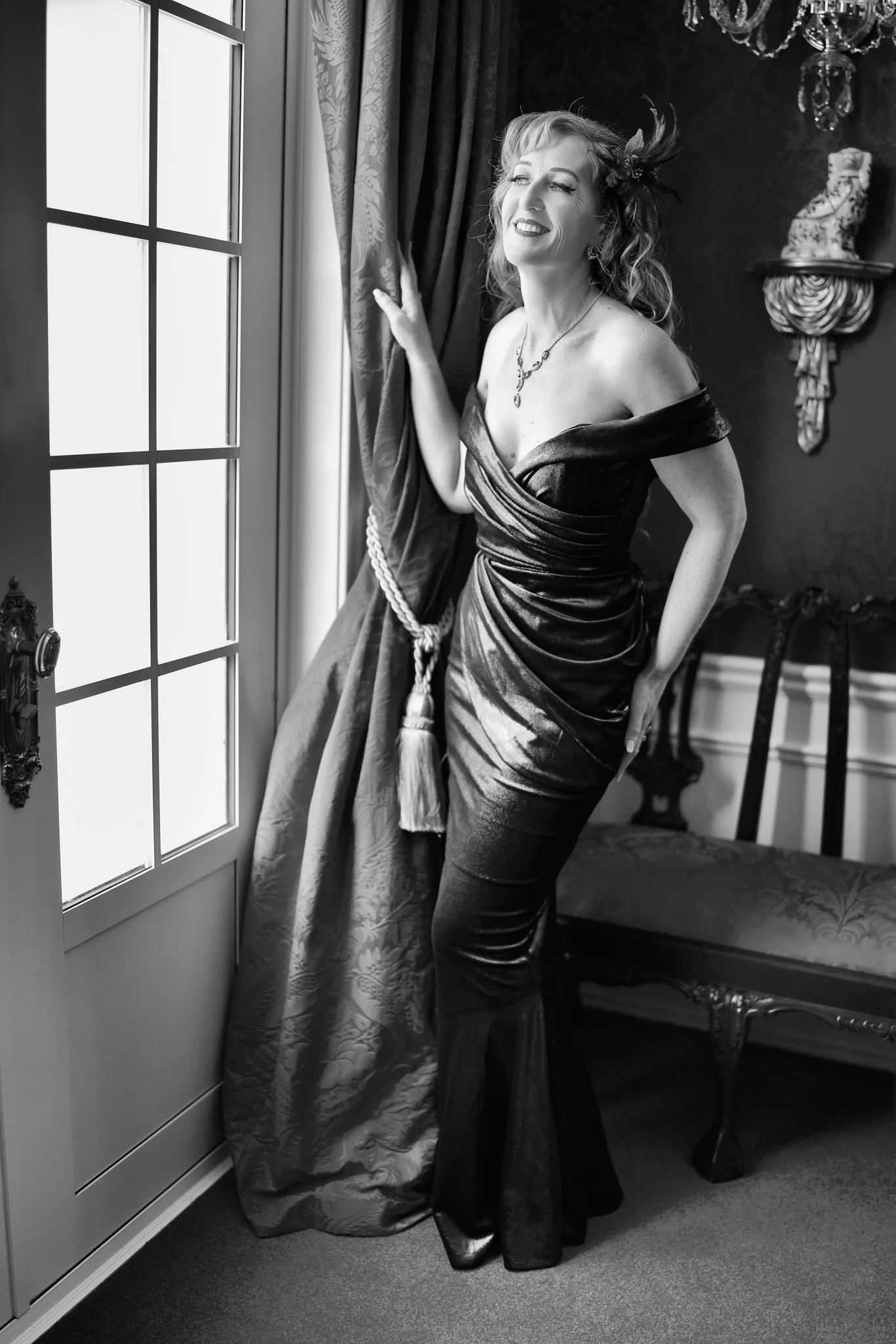 Black and white photo of Sandy by a tall window
