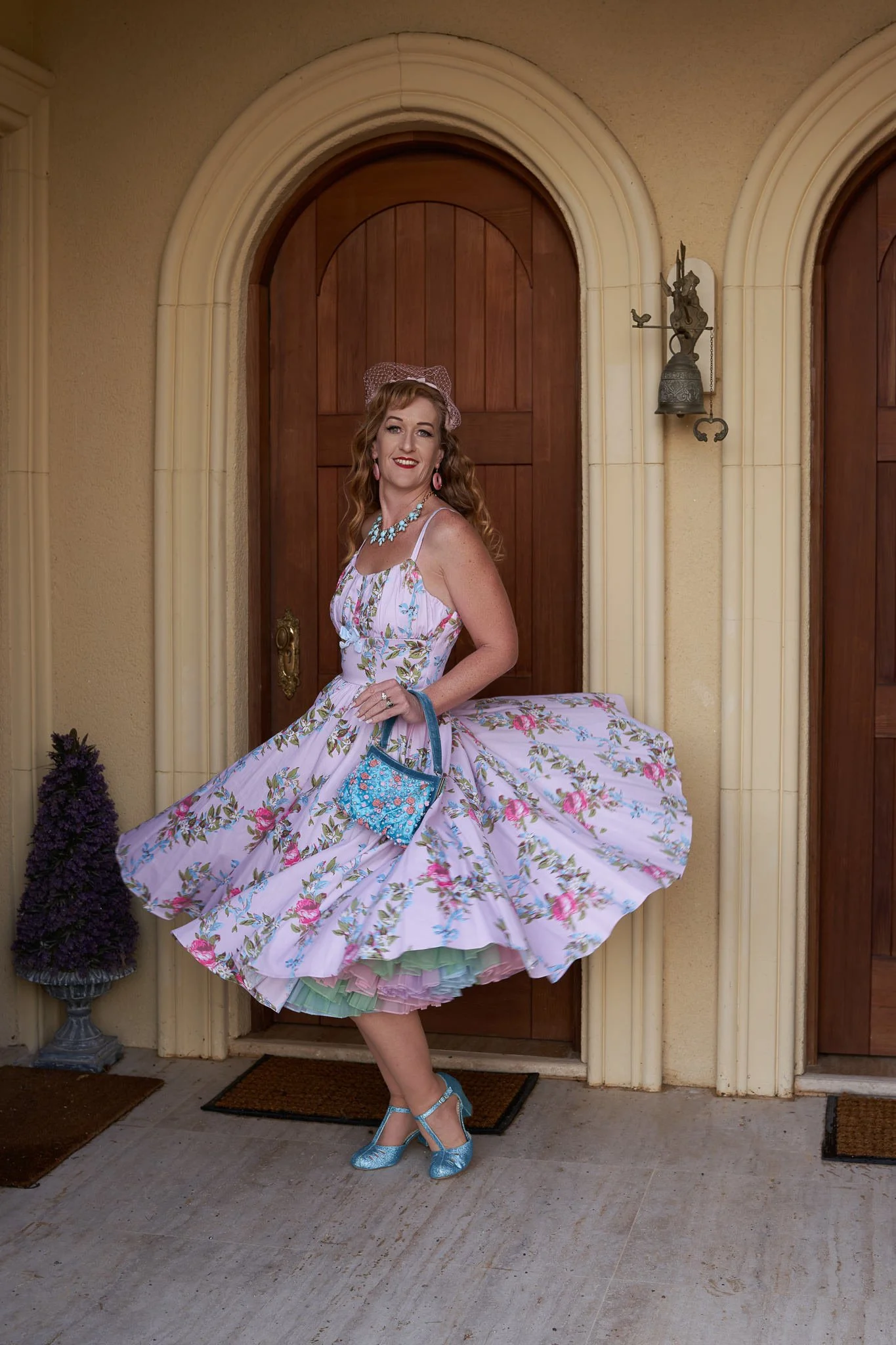 Sandy twirls her floral dress beneath an arched doorway