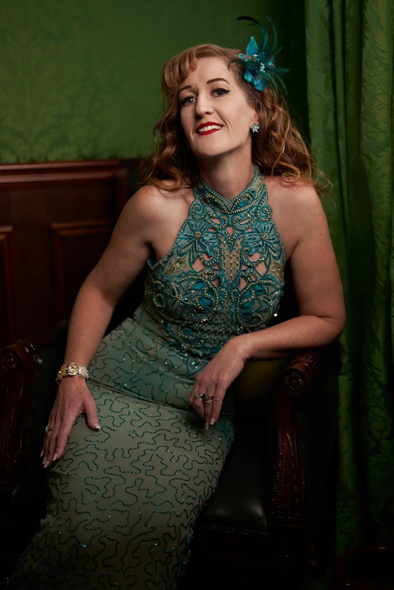 Sandy in a beaded green gown against a green wall