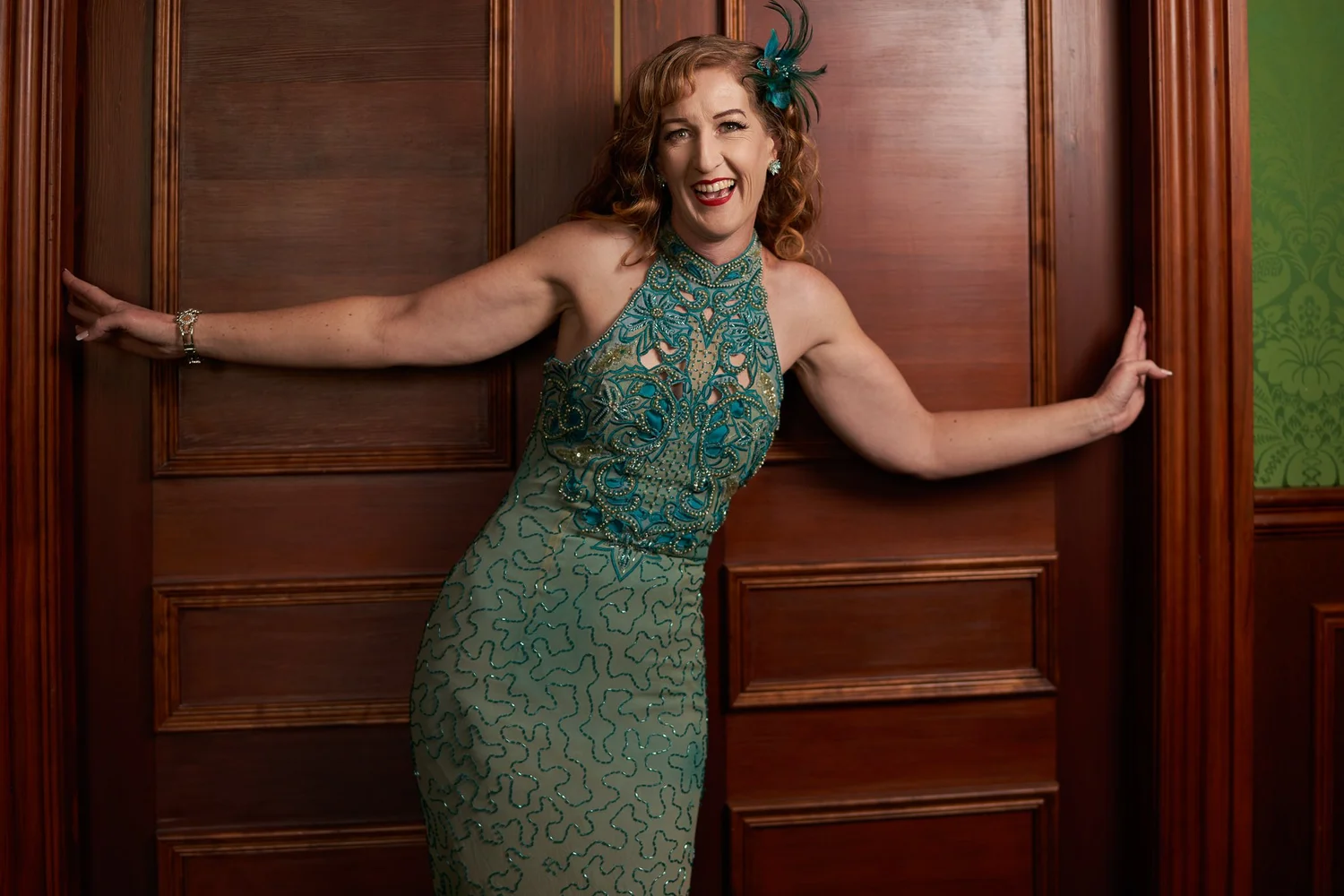 Sandy stretches her arms across a wooden doorway