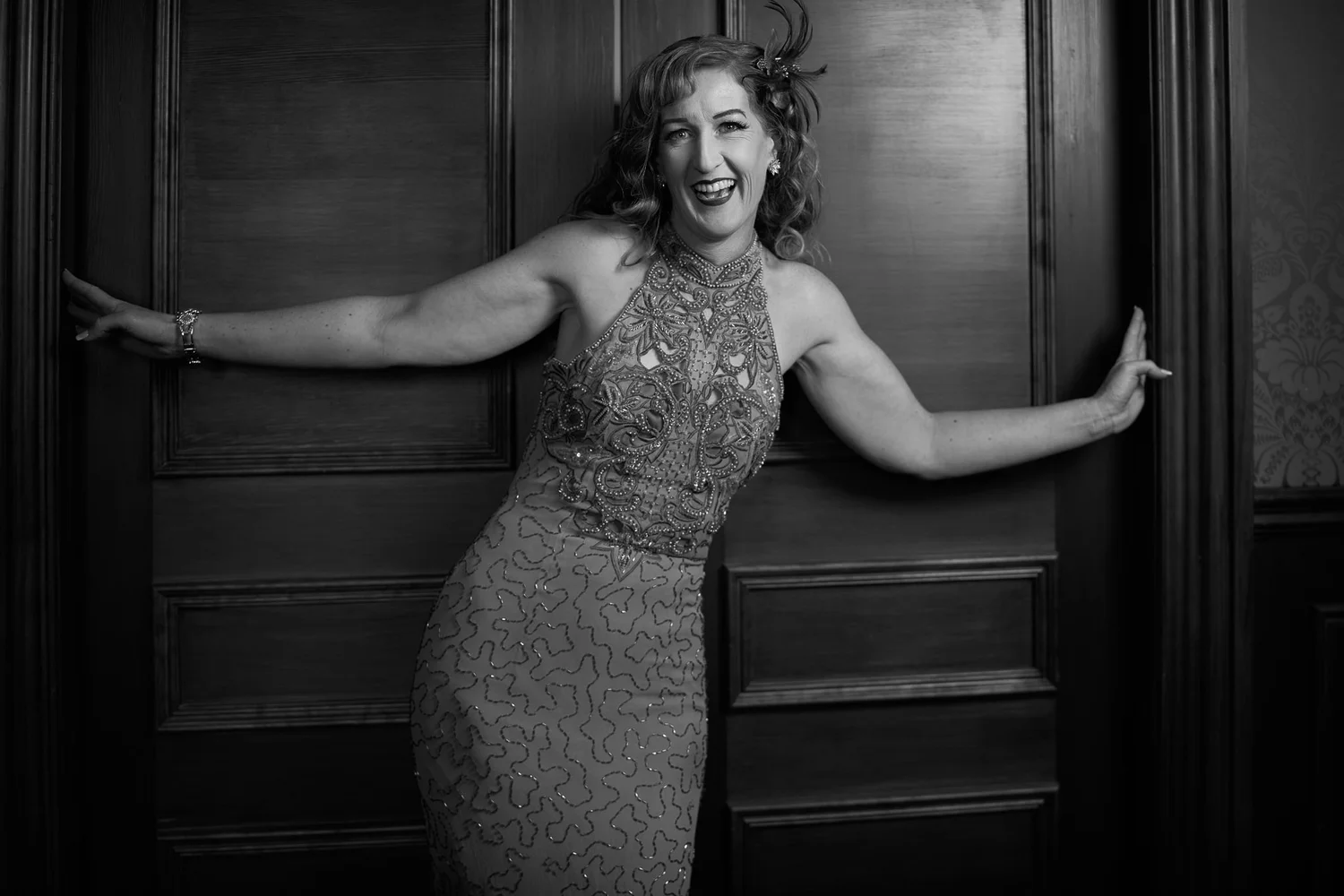 Black and white photo of Sandy in a doorway with arms outstretched