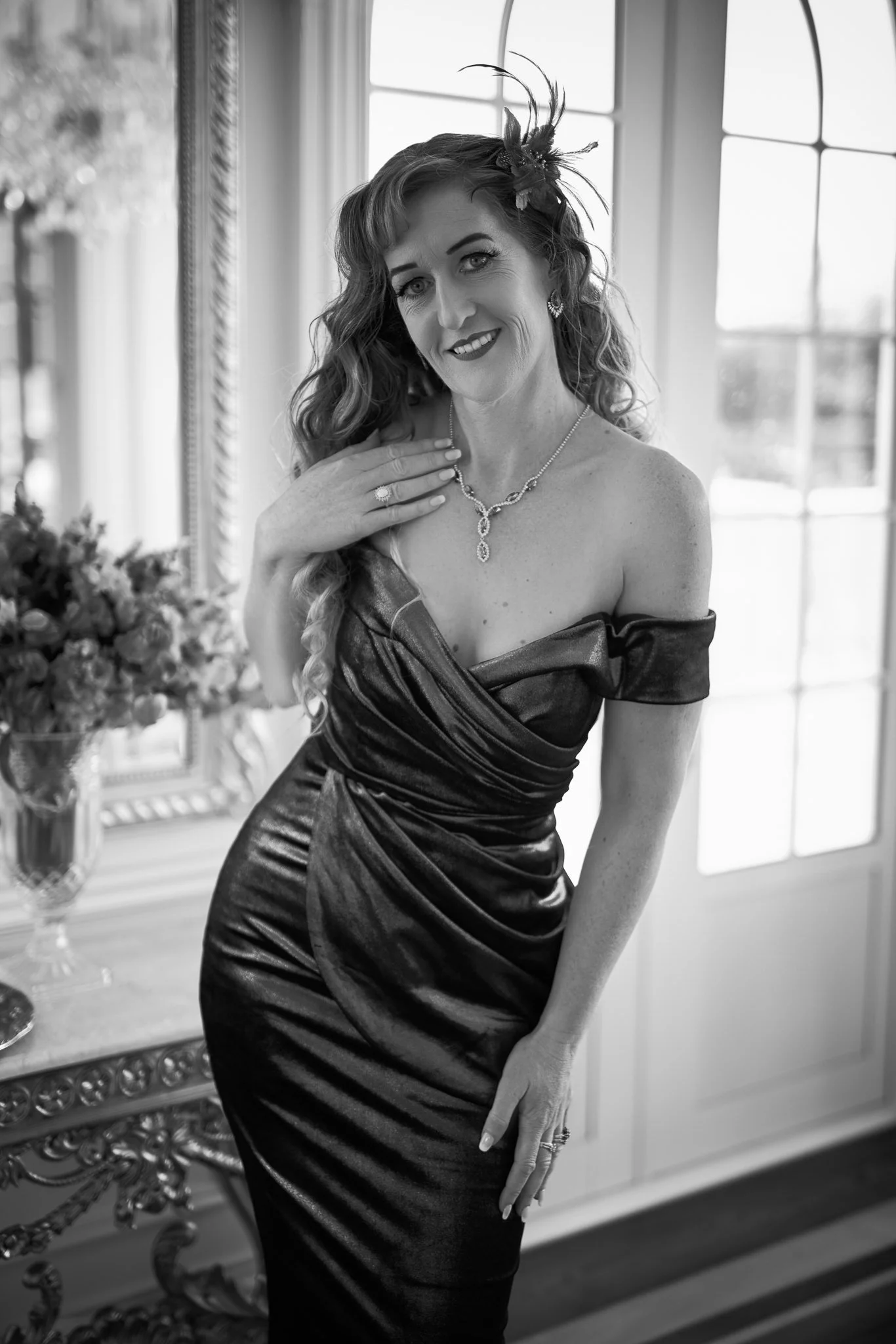 Black and white photo of Sandy with a hand at her collarbone