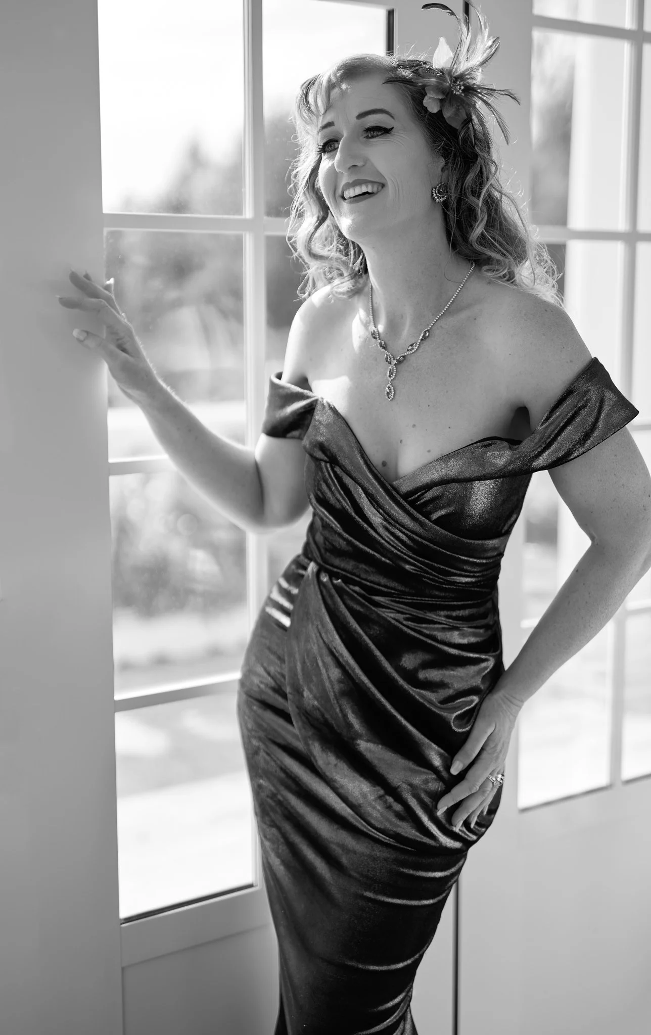 Black and white photo of Sandy laughing by the window