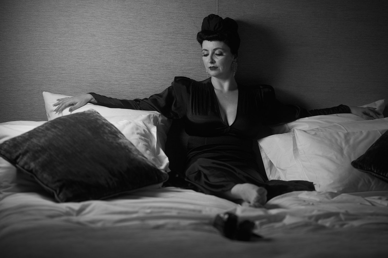 Black and white photo of Viv reclining on a hotel bed