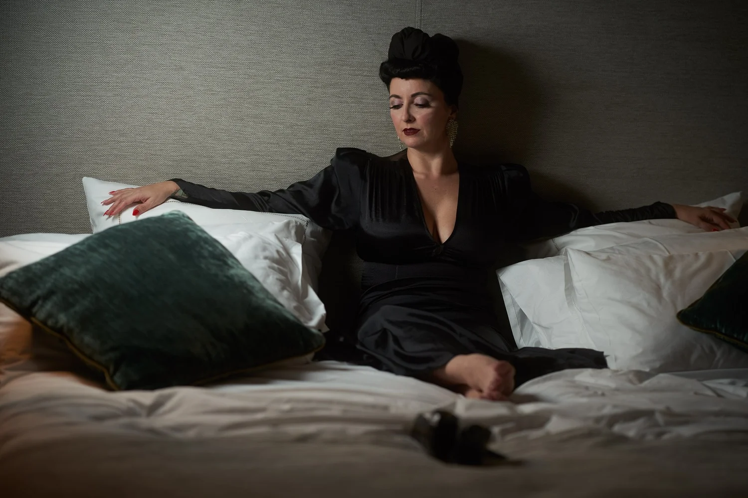 Viv reclines against cushions on a hotel bed