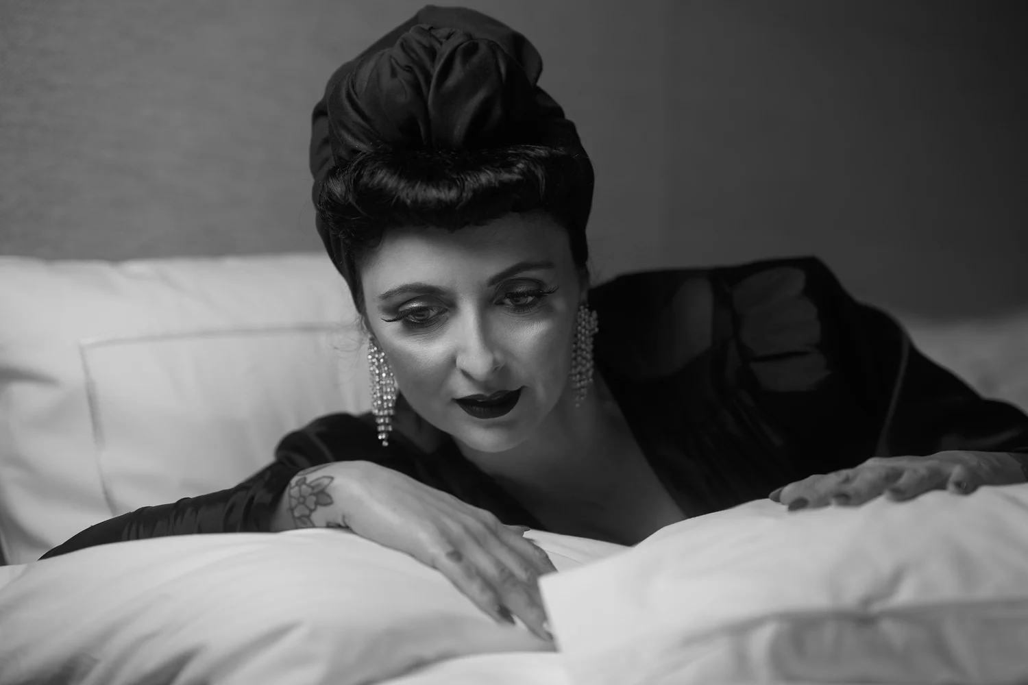 Black and white photo of Viv leaning on pillows