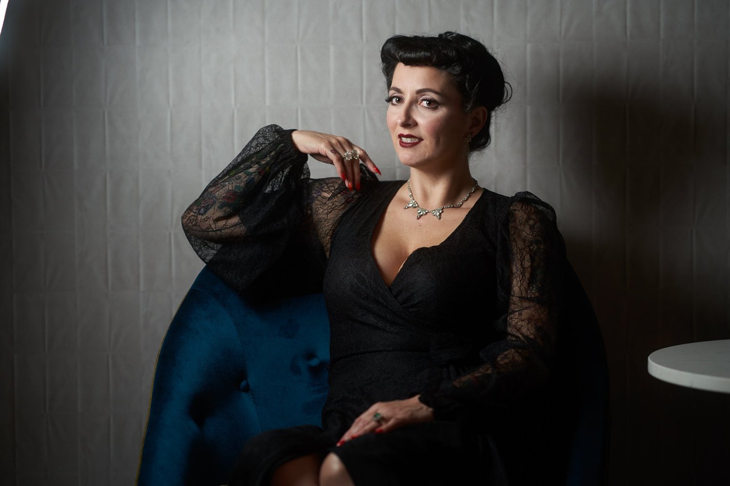 Viv seated with a hand behind her head in a teal chair