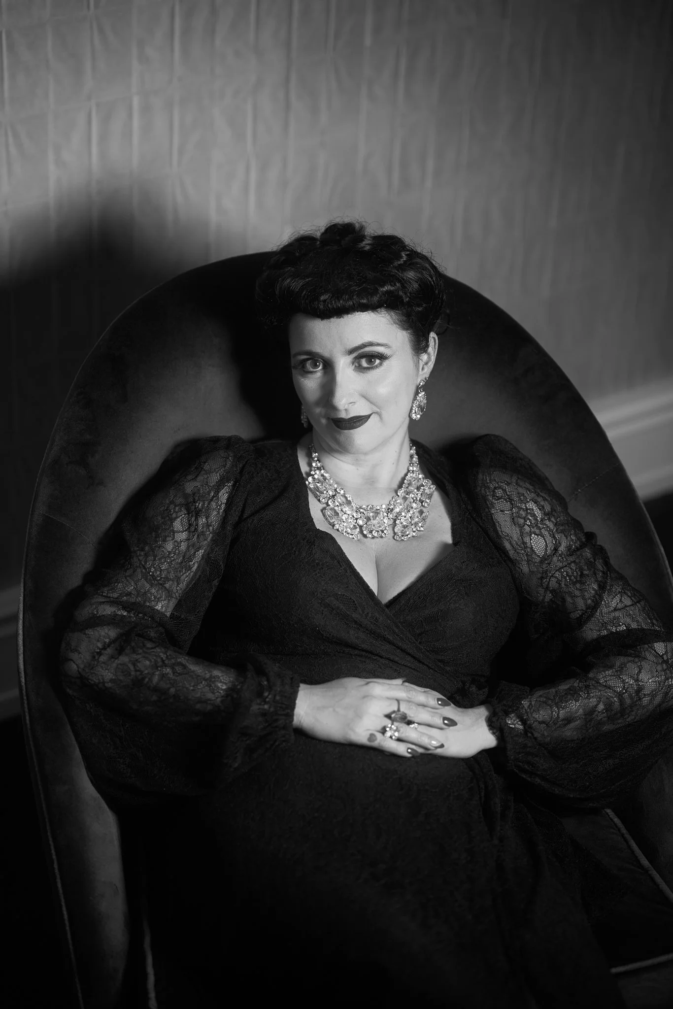 Black and white photo of Viv in a velvet armchair
