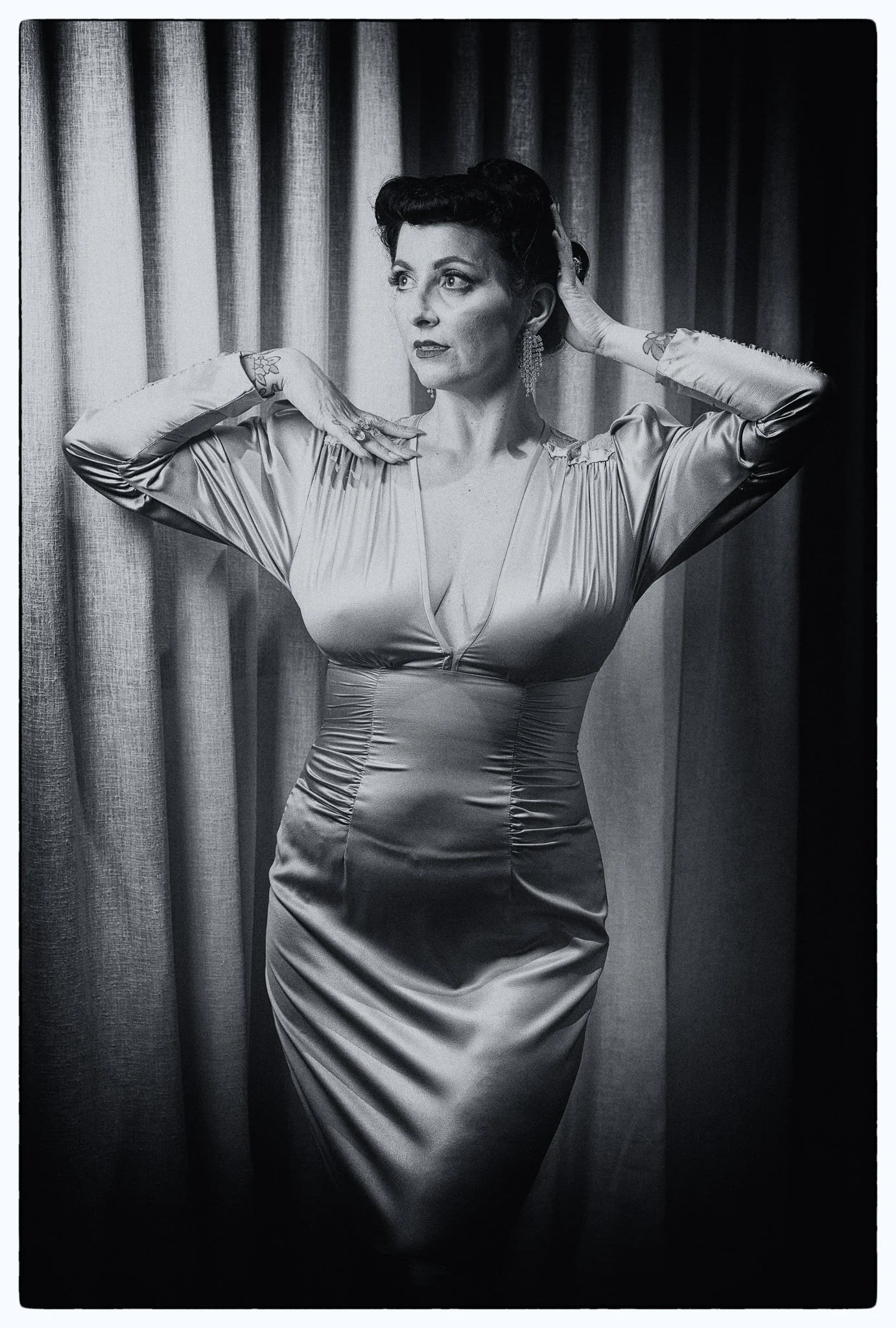 Black and white photo of Viv in satin with hands behind her head
